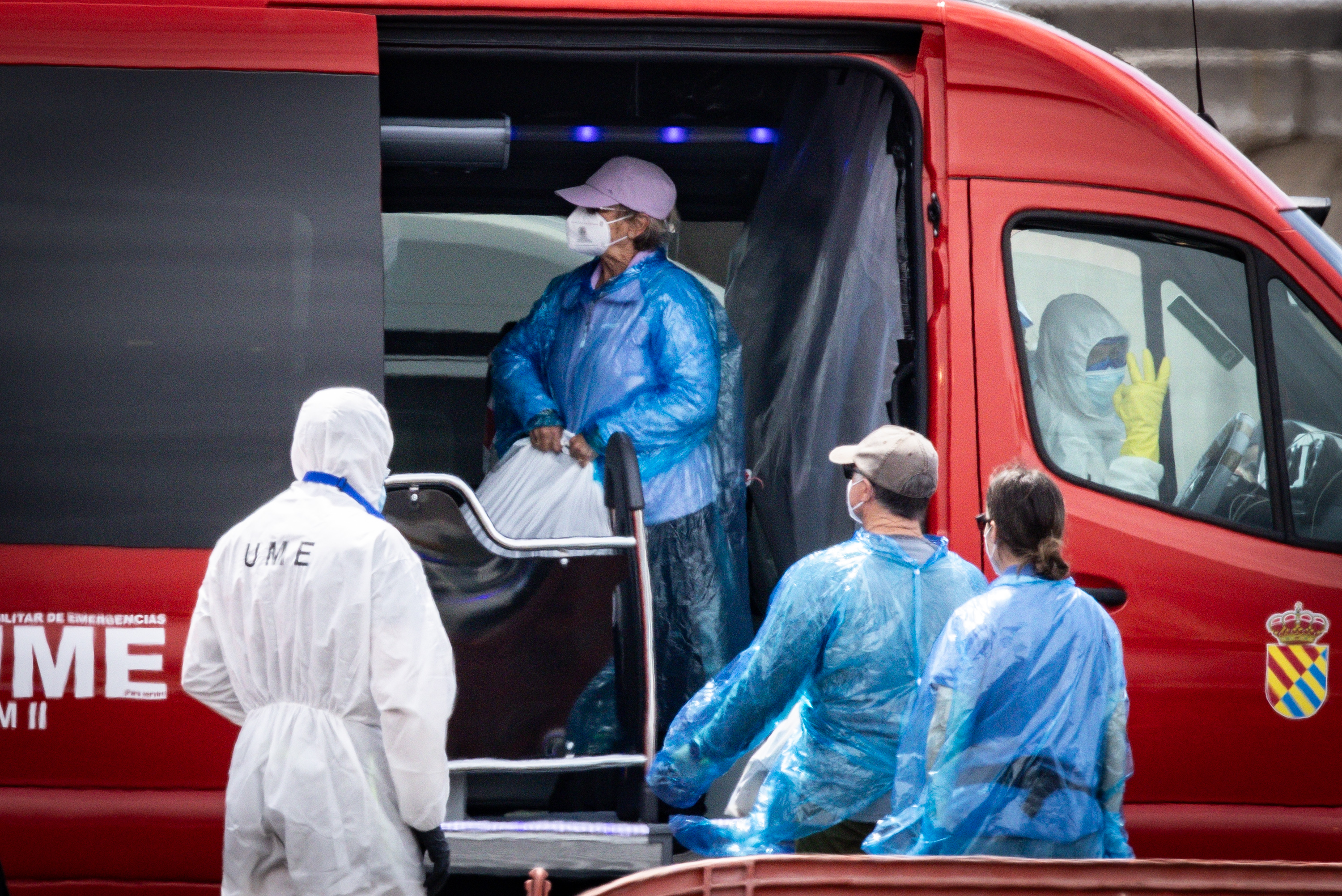 Un passager transporte ses affaires dans un sac en plastique vers un bus qui l'attend après avoir été évacué du MV Hondius à son arrivée au port de Granadilla, le 10 mai 2026, à Ténérife, dans l'archipel des Canaries, en Espagne. | Source : Getty Images