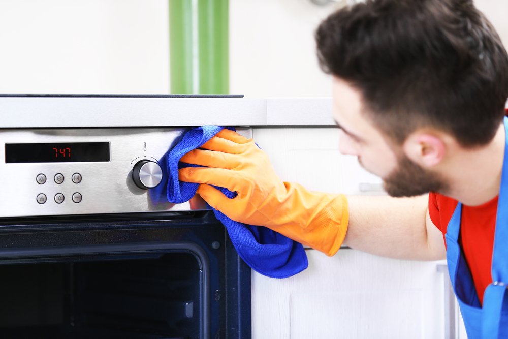 Une personne qui nettoie le four de la cuisine | Photo : Shutterstock