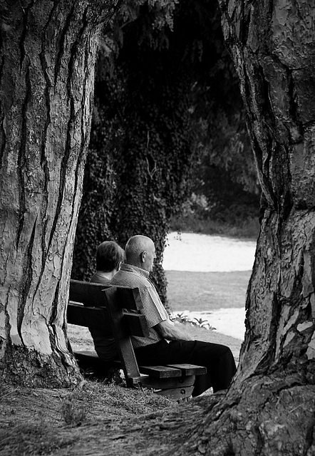 Un couple de personnes âgées assis sur un banc. l Source: Flickr