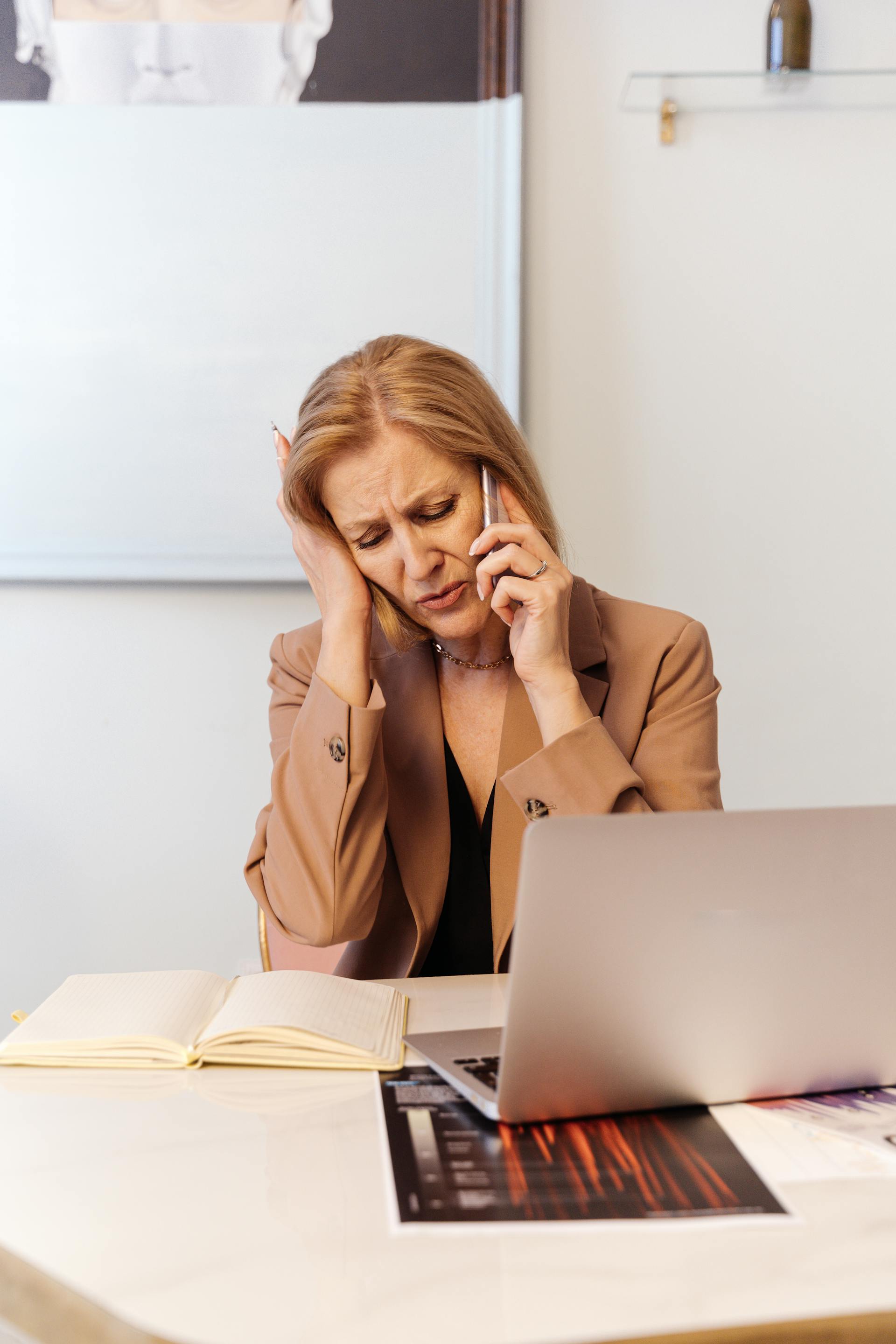 Une femme âgée frustrée se tenant la tête tout en parlant au téléphone | Source : Pexels