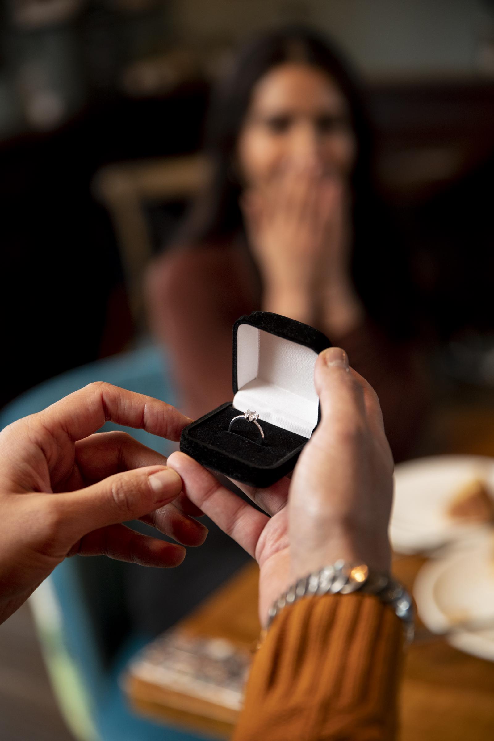 Gros plan d'un homme tenant une petite boîte en velours avec une bague en diamant | | Source : Freepik