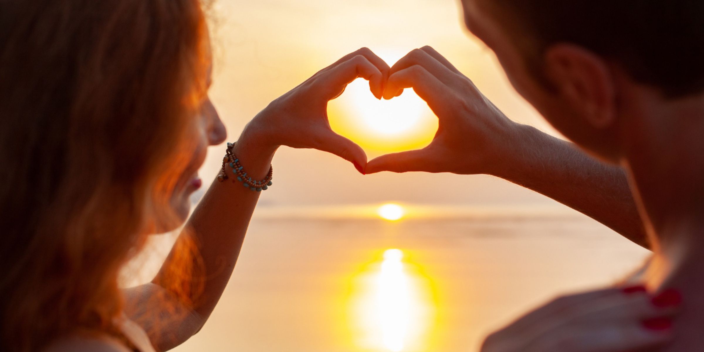 Un couple qui forme un cœur avec ses mains | Source : Magnific
