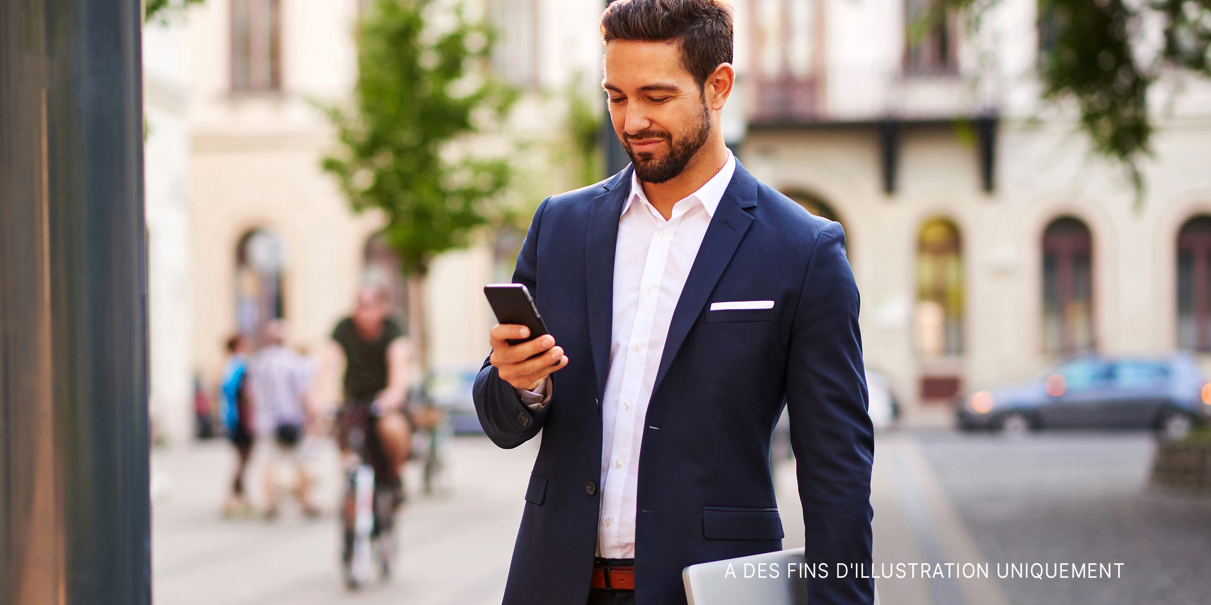 Un jeune homme d'affaires à l'allure agréable utilisant le téléphone. | Source : Shutterstock