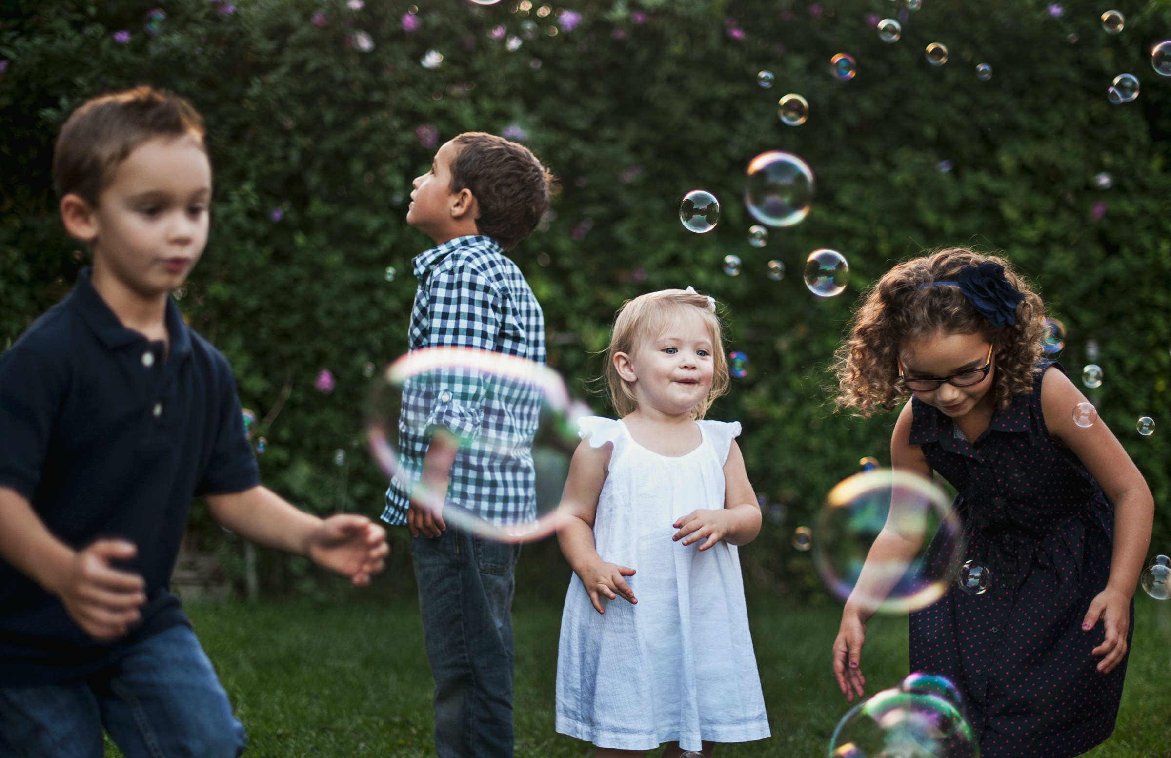 Enfants jouant avec des bulles en plein air | Source : Unsplash