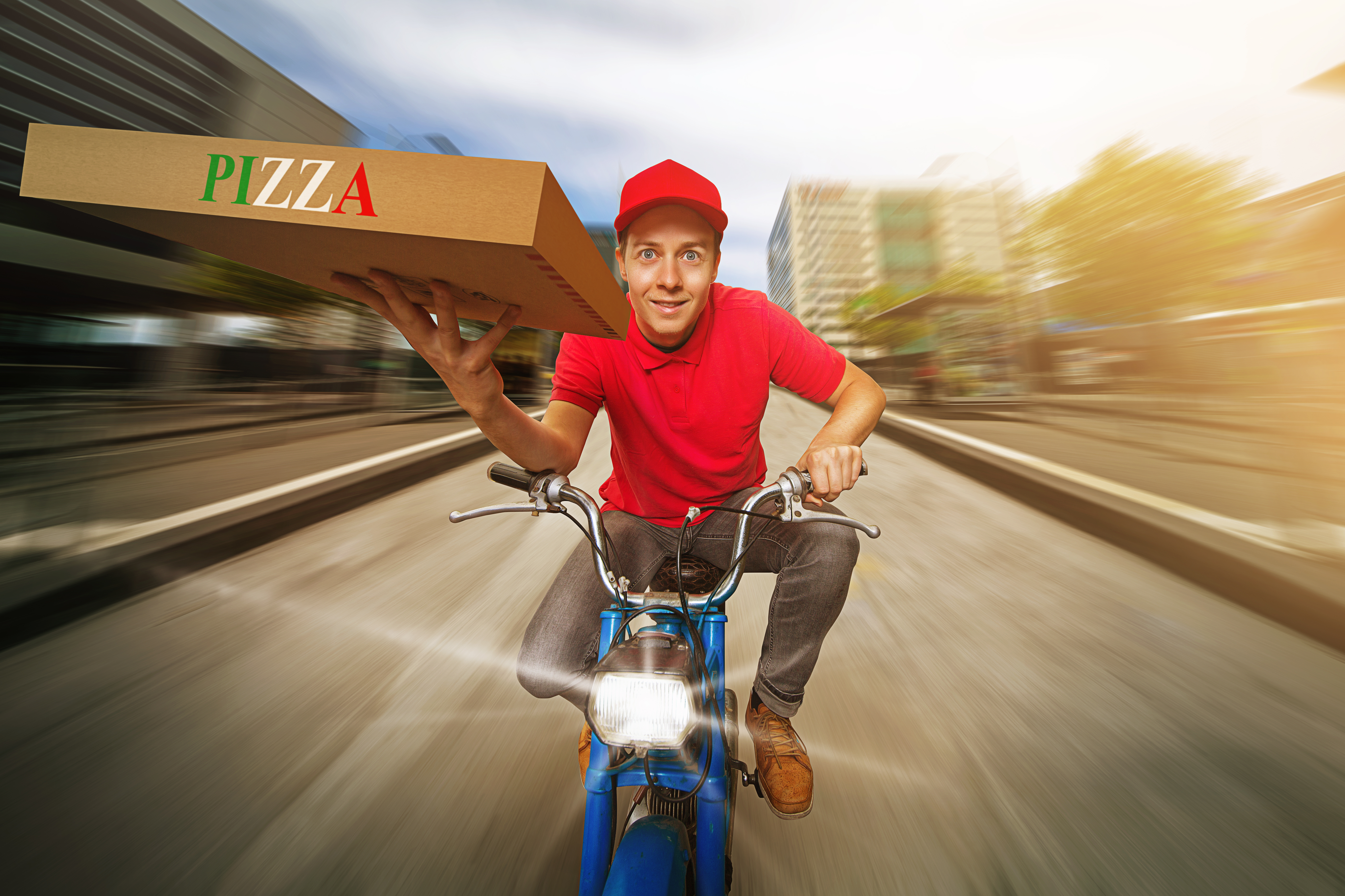 Un livreur de pizzas qui roule à toute vitesse sur une route | Source : Shutterstock