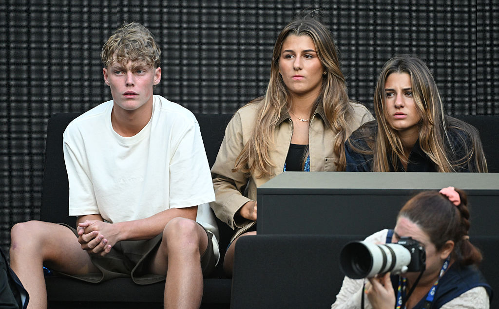 Cruz Hewitt est assis avec Myla et Charlene Federer alors qu'ils regardent Jannik Sinner (Italie) affronter Hugo Gaston (France) lors du premier tour du simple messieurs de l'Open d'Australie 2026 au Melbourne Park, le 20 janvier 2026 à Melbourne, en Australie I Source : Getty Images