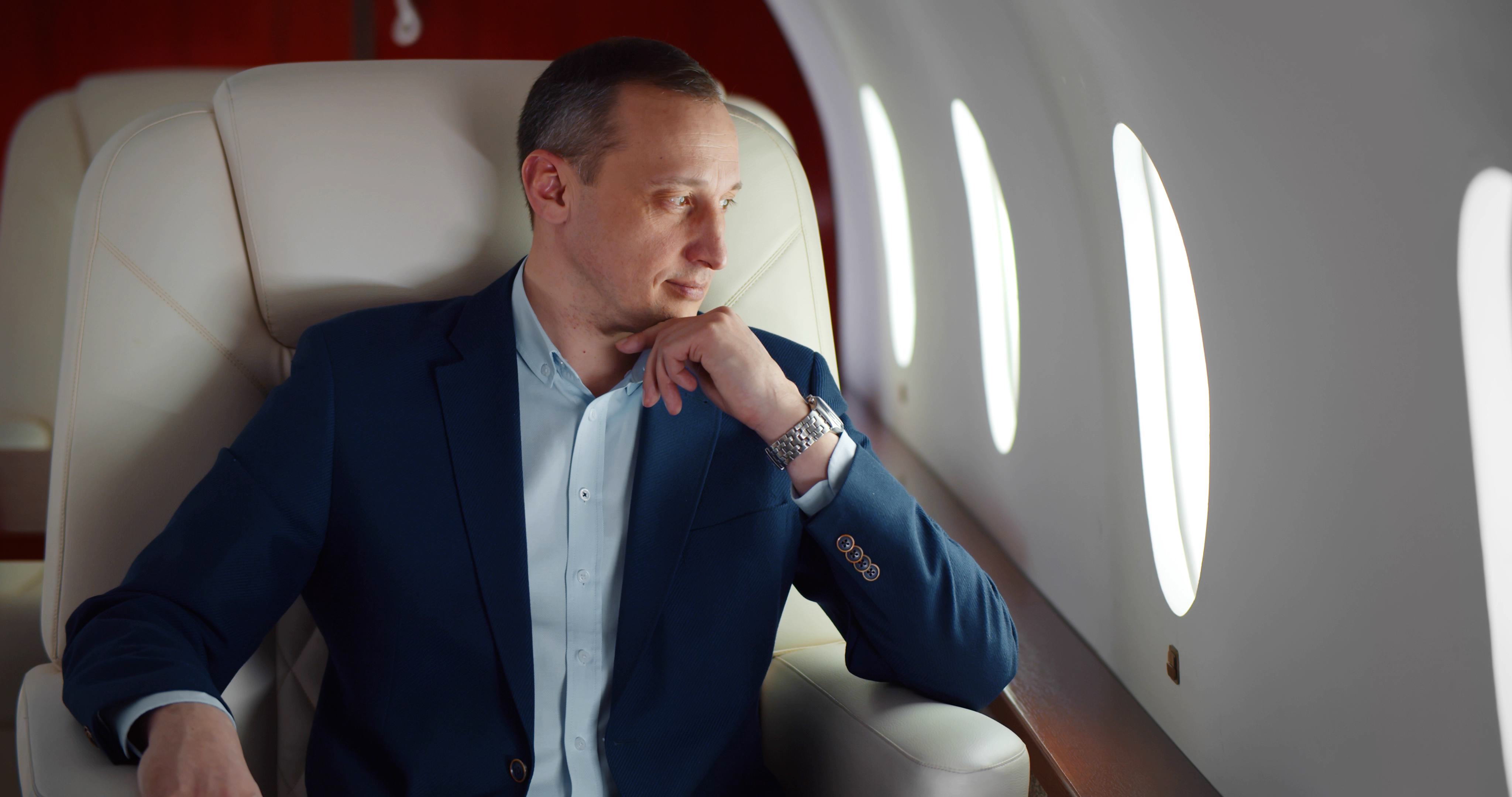 Un homme d'affaires en costume est photographié sur un vol en première classe | Source : Shutterstock