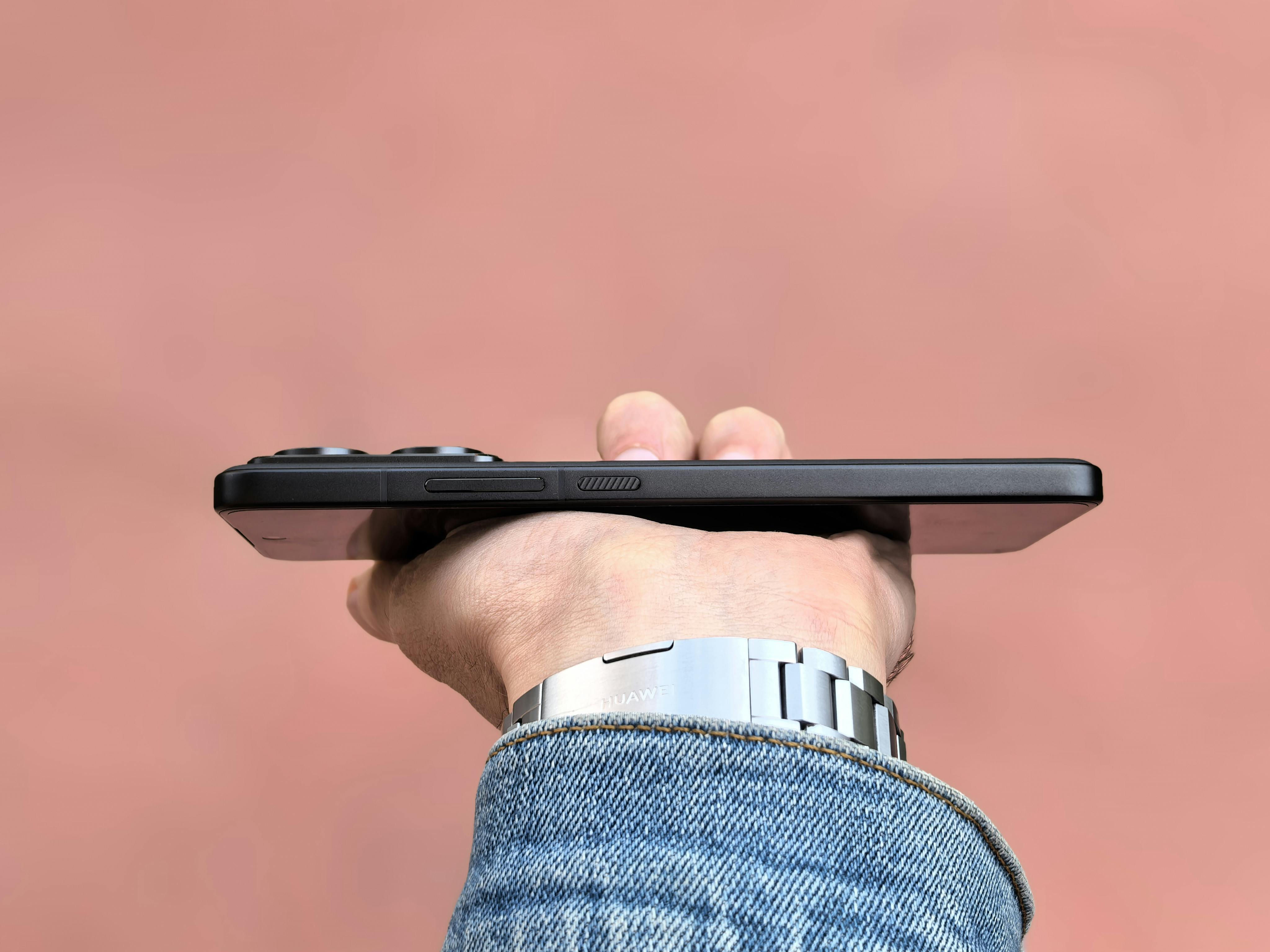 Un homme qui tend son téléphone | Source : Pexels