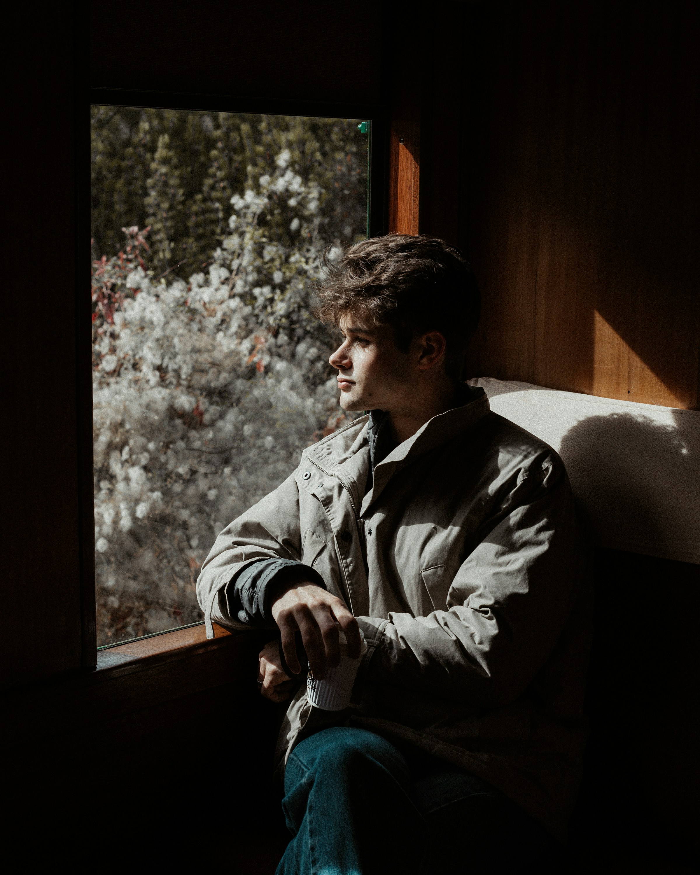 Un jeune garçon assis sur le siège de la fenêtre d'un train | Source : Unsplash