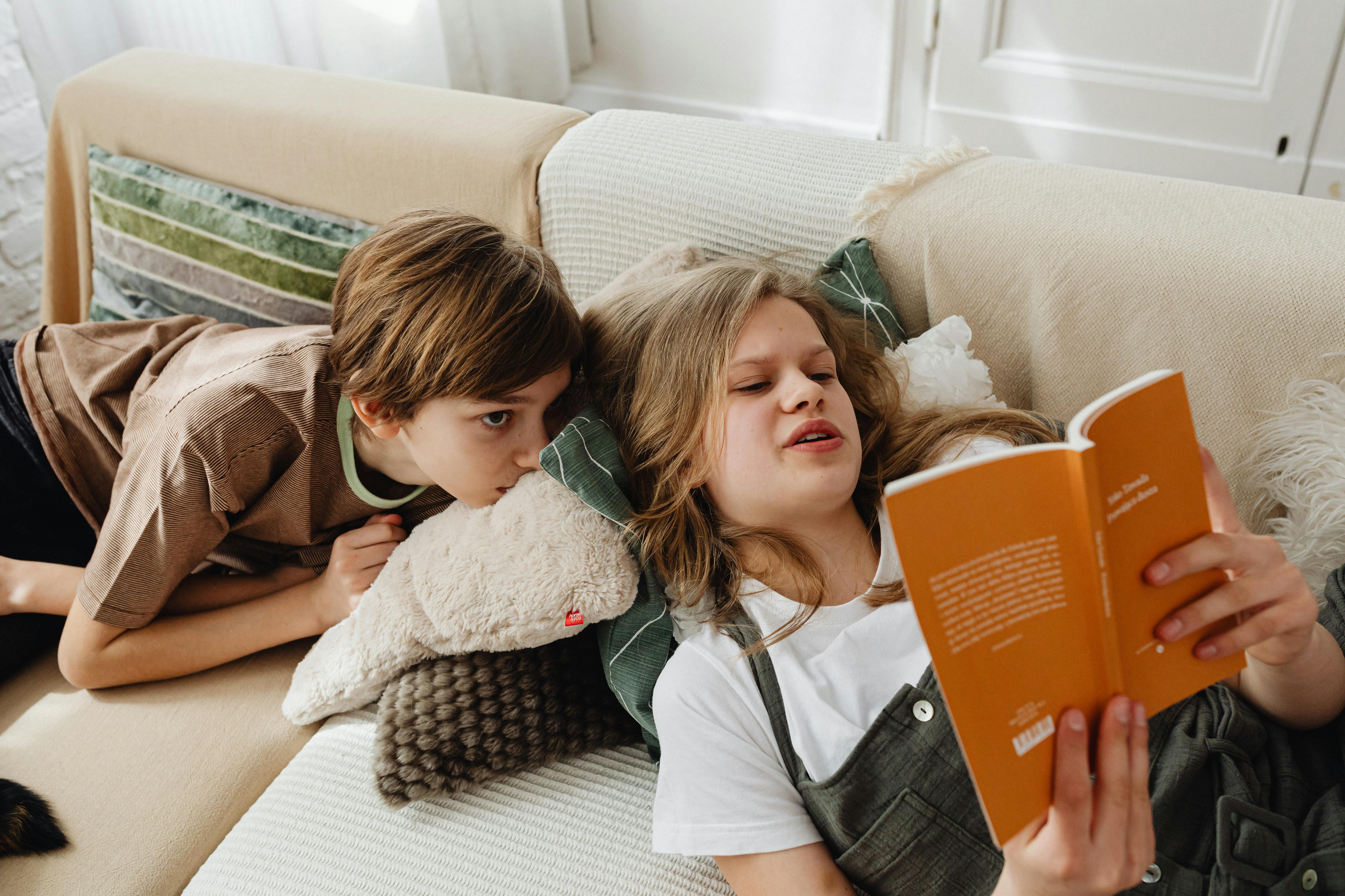 Une fille fait la lecture à son frère | Source : Pexels