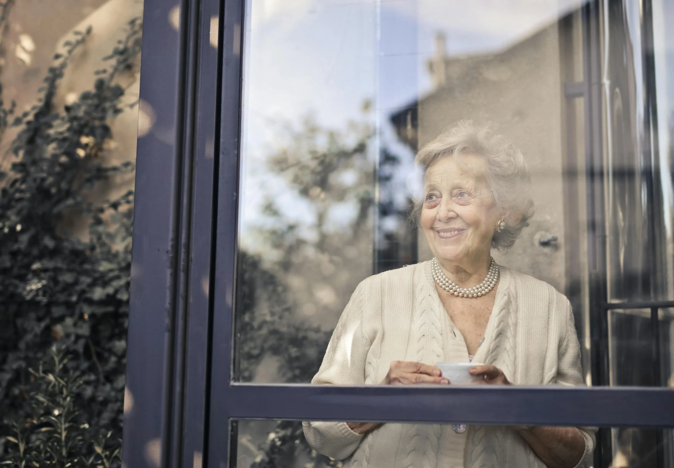 Une femme âgée souriante sous son porche | Source : Pexels