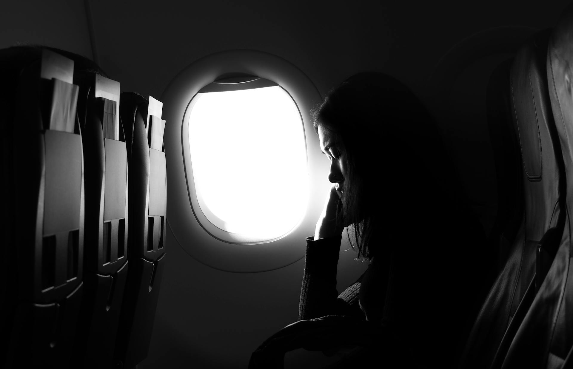 Une jeune femme assise près du hublot dans un avion | Source : Pexels