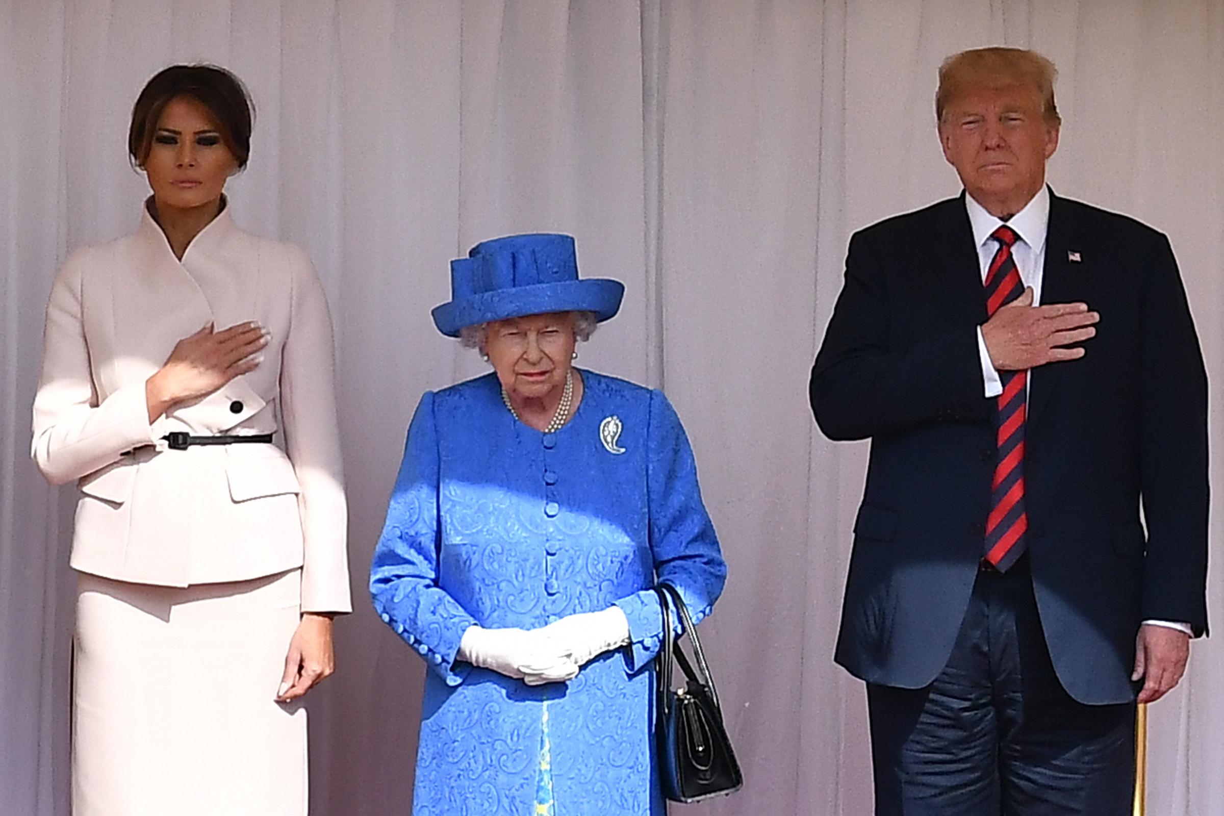 La reine Élisabeth II se tient avec le président américain Donald Trump et la première dame Melania Trump sur les dias dans le quadrilatère du château de Windsor, le 13 juillet 2018 à Windsor, en Angleterre | Source : Getty Images