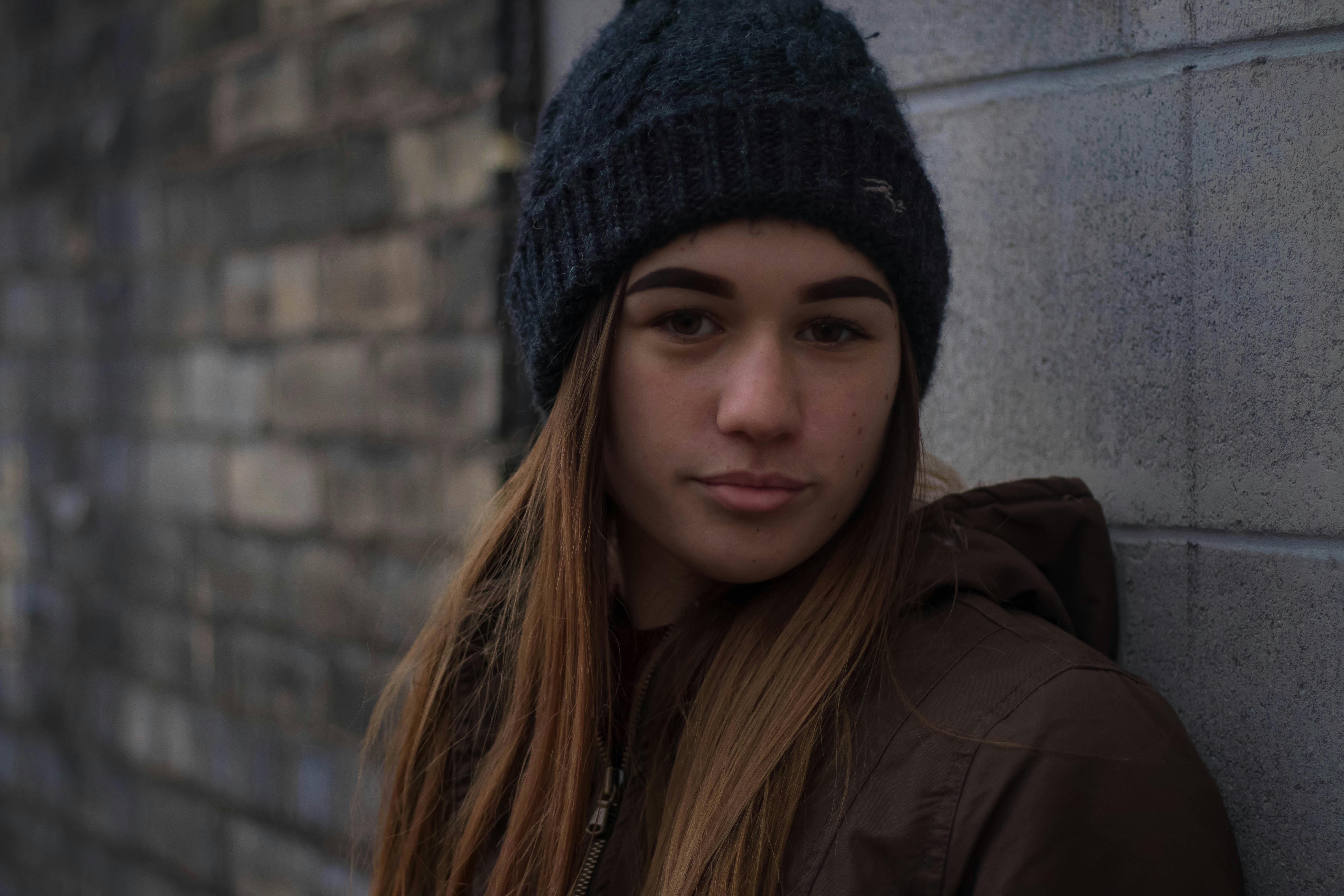 Une adolescente à l'allure neutre debout contre un mur | Source : Pexels