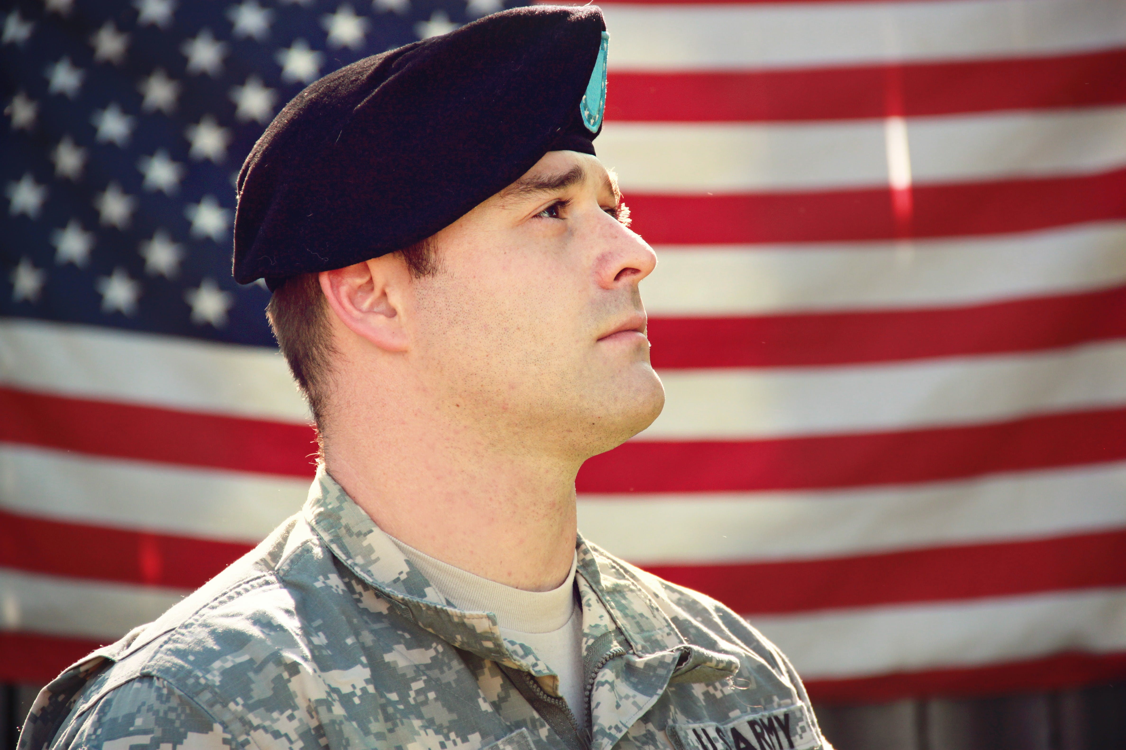 Un soldat en uniforme avec le drapeau américain derrière lui | Source : Pexels