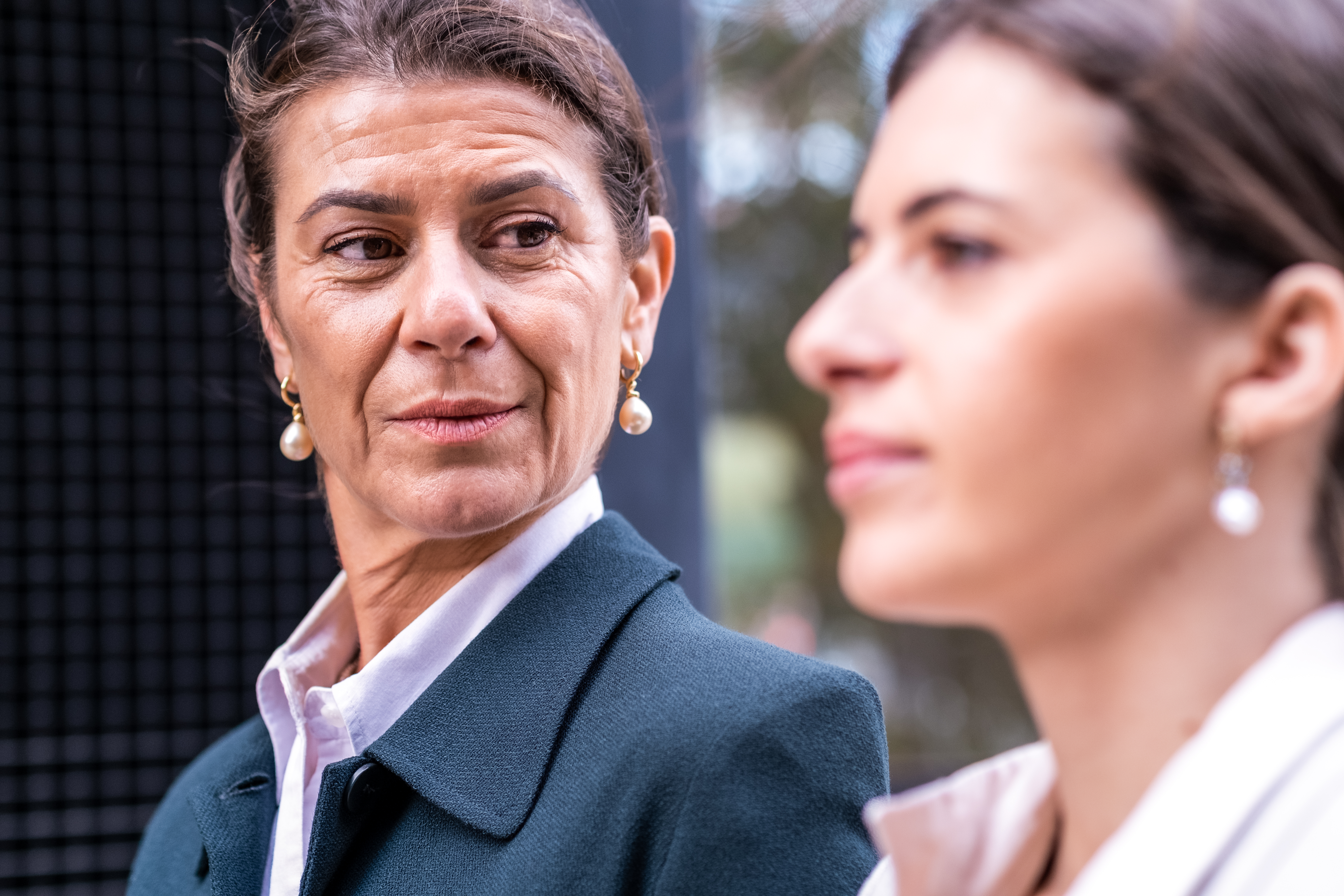 Une femme d'affaires d'âge mûr et fortunée et sa fille d'âge moyen discutent calmement des affaires de la famille dans un endroit extérieur de la ville : Getty Images