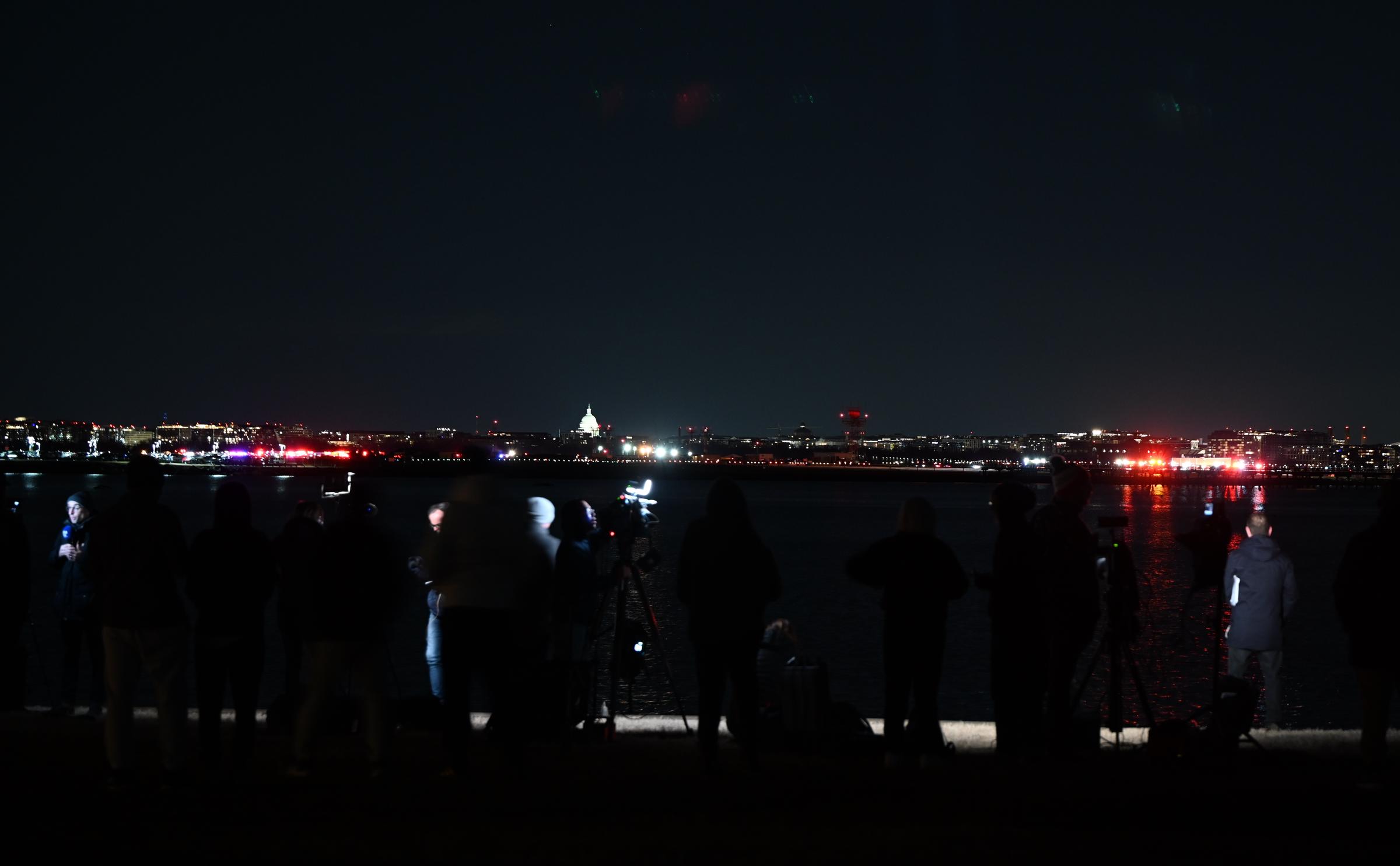 Des membres de la presse près de la zone de la scène après qu'un avion régional est entré en collision en plein vol avec un hélicoptère militaire et se soit écrasé dans la rivière Potomac à Washington, D.C., le 30 janvier 2025. | Source : Getty Images