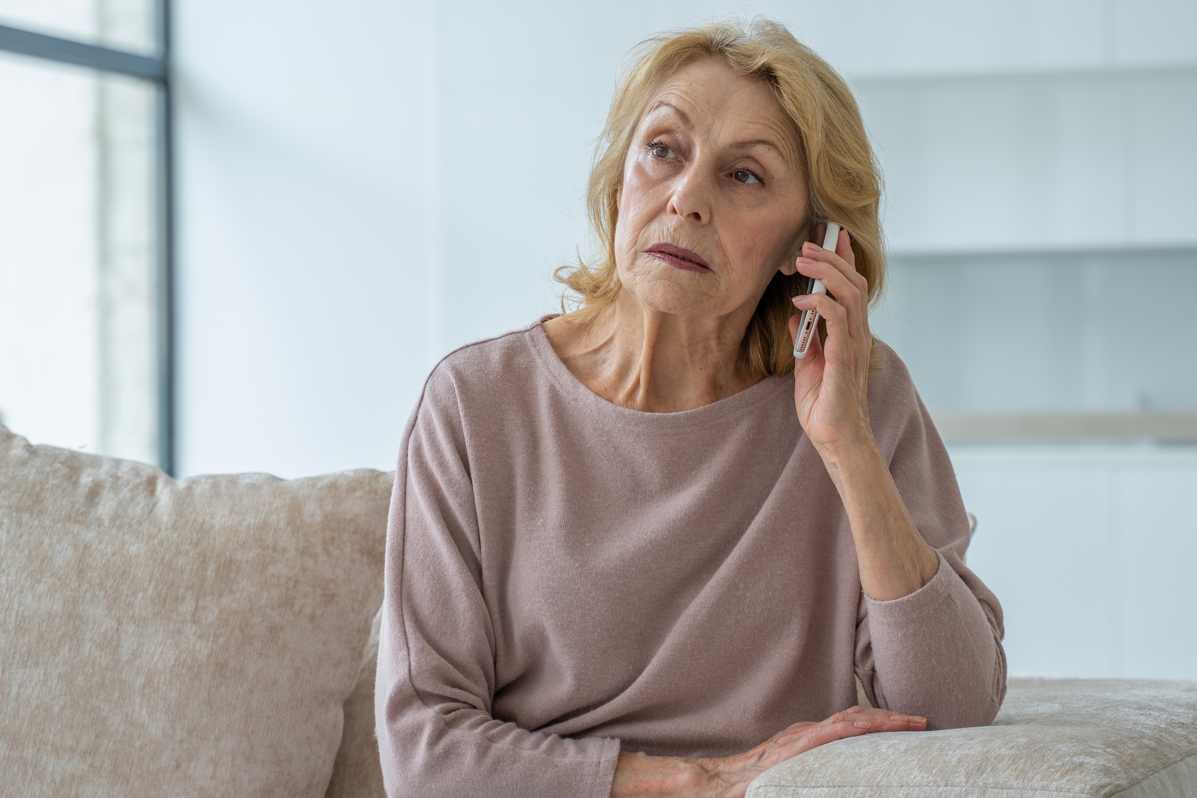 Une femme âgée à l'air triste alors qu'elle est au téléphone | Source : Shutterstock