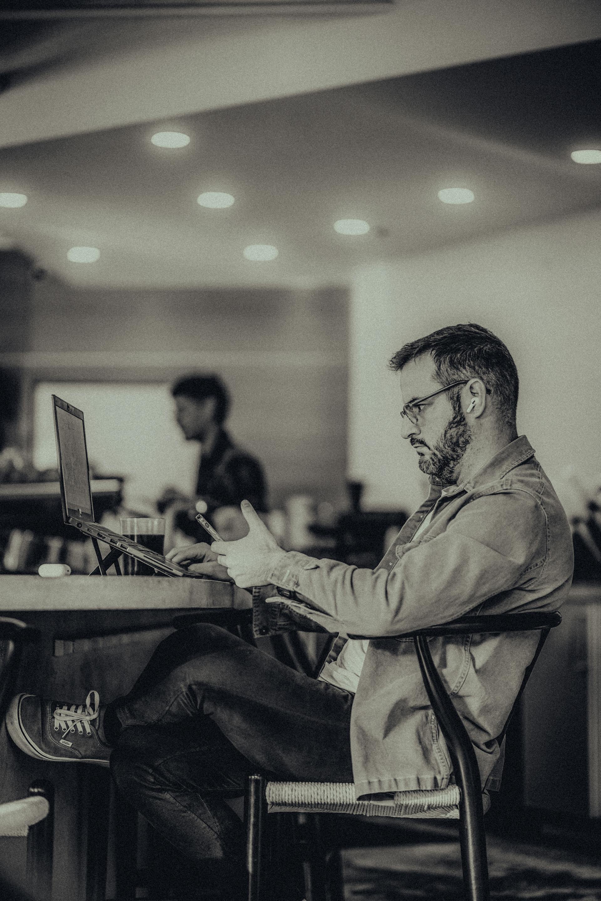 Un homme assis dans un bureau et utilisant son téléphone | Source : Pexels