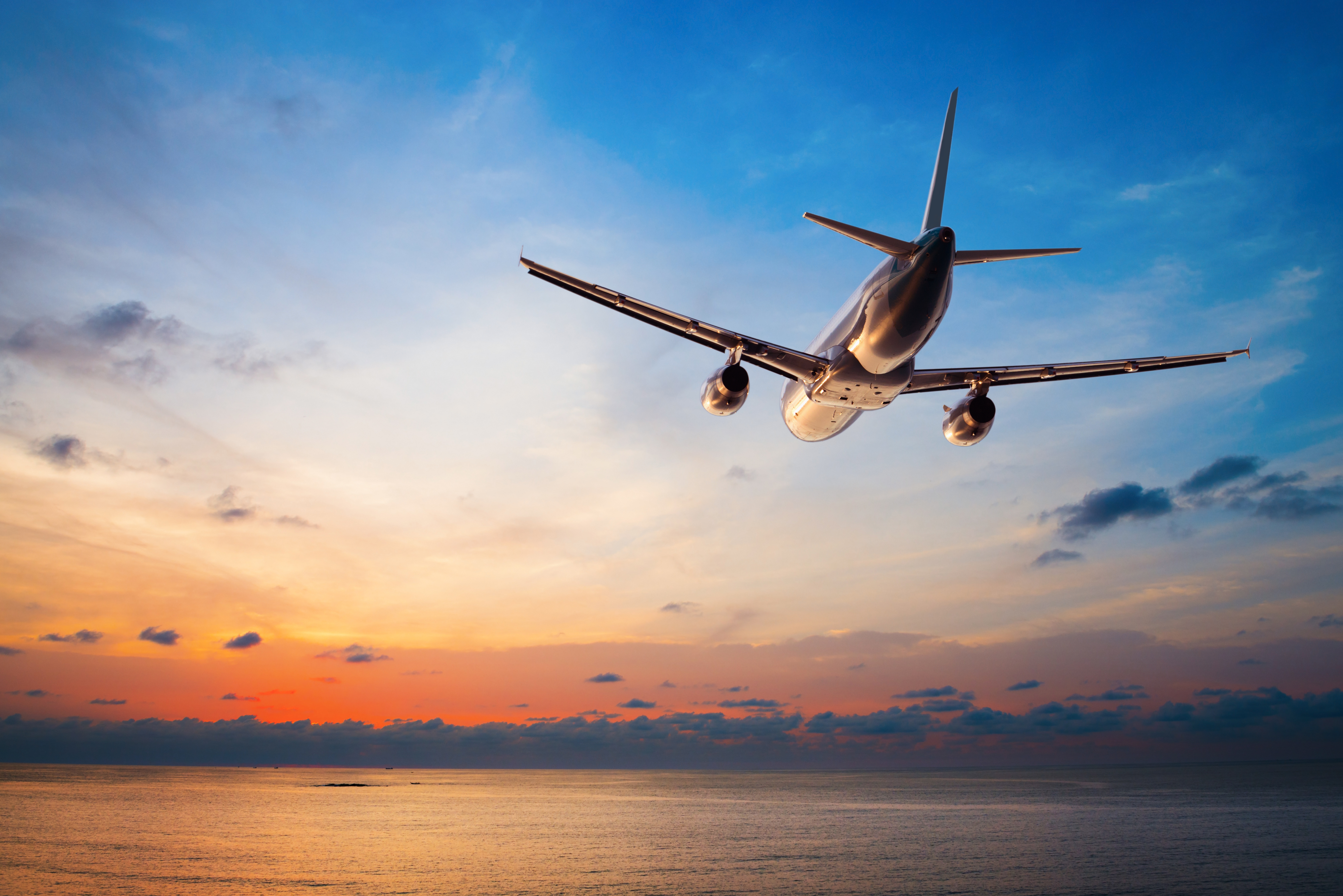 Un avion volant sur fond de coucher de soleil | Source : Shutterstock