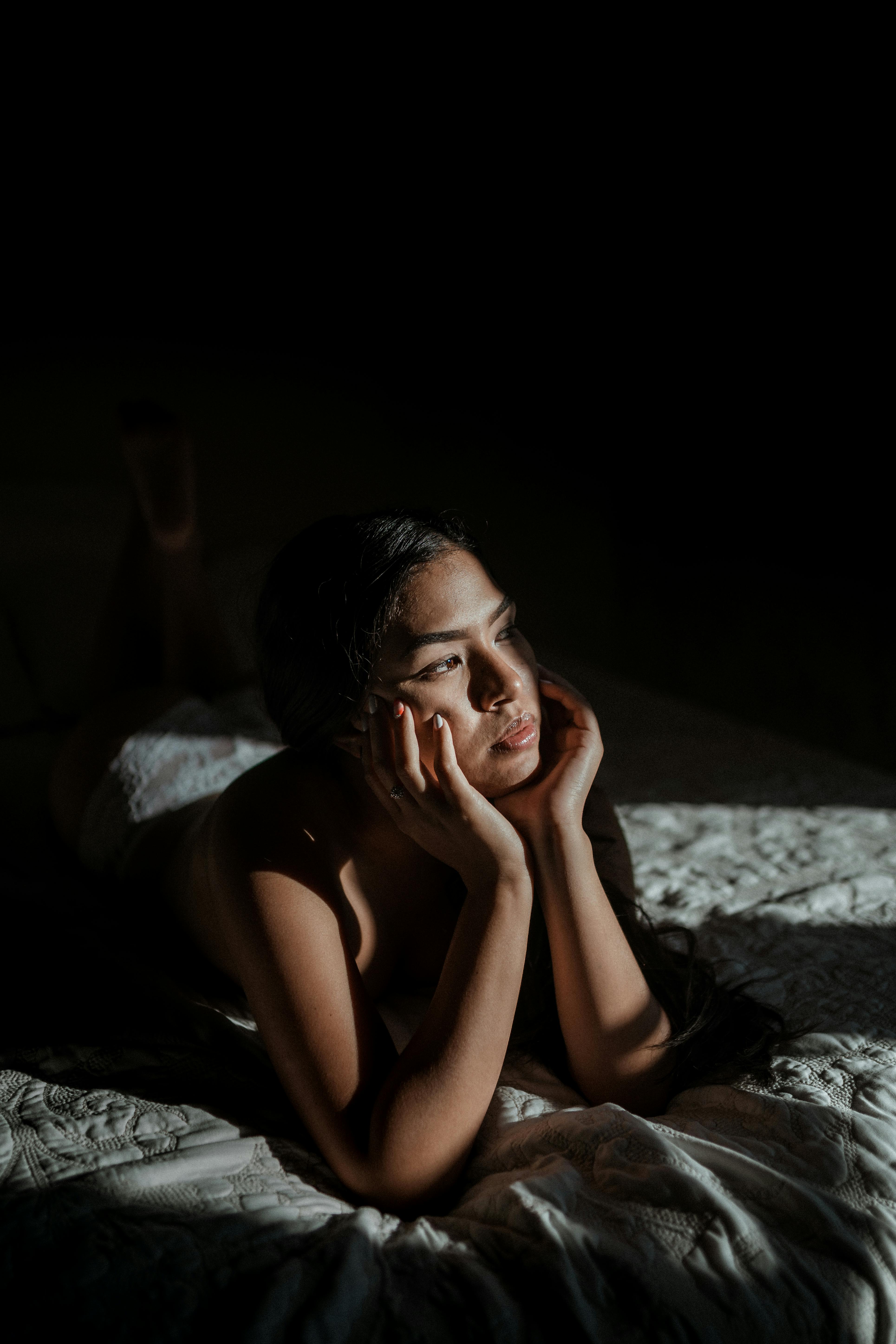 Femme réfléchissant au lit | Source : Pexels