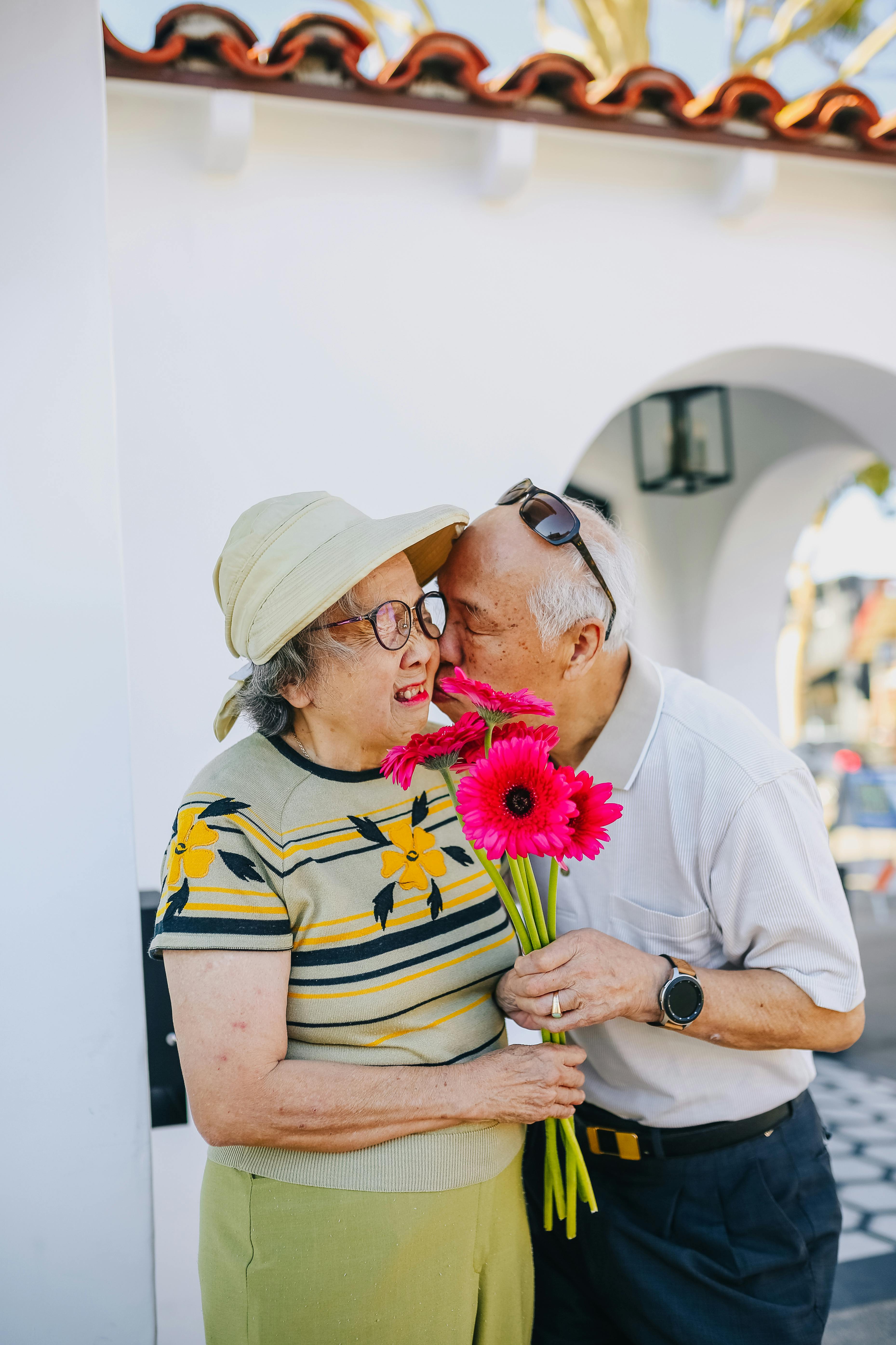 Un couple se montre romantique tandis que la femme reçoit un bouquet de fleurs | Source : Pexels