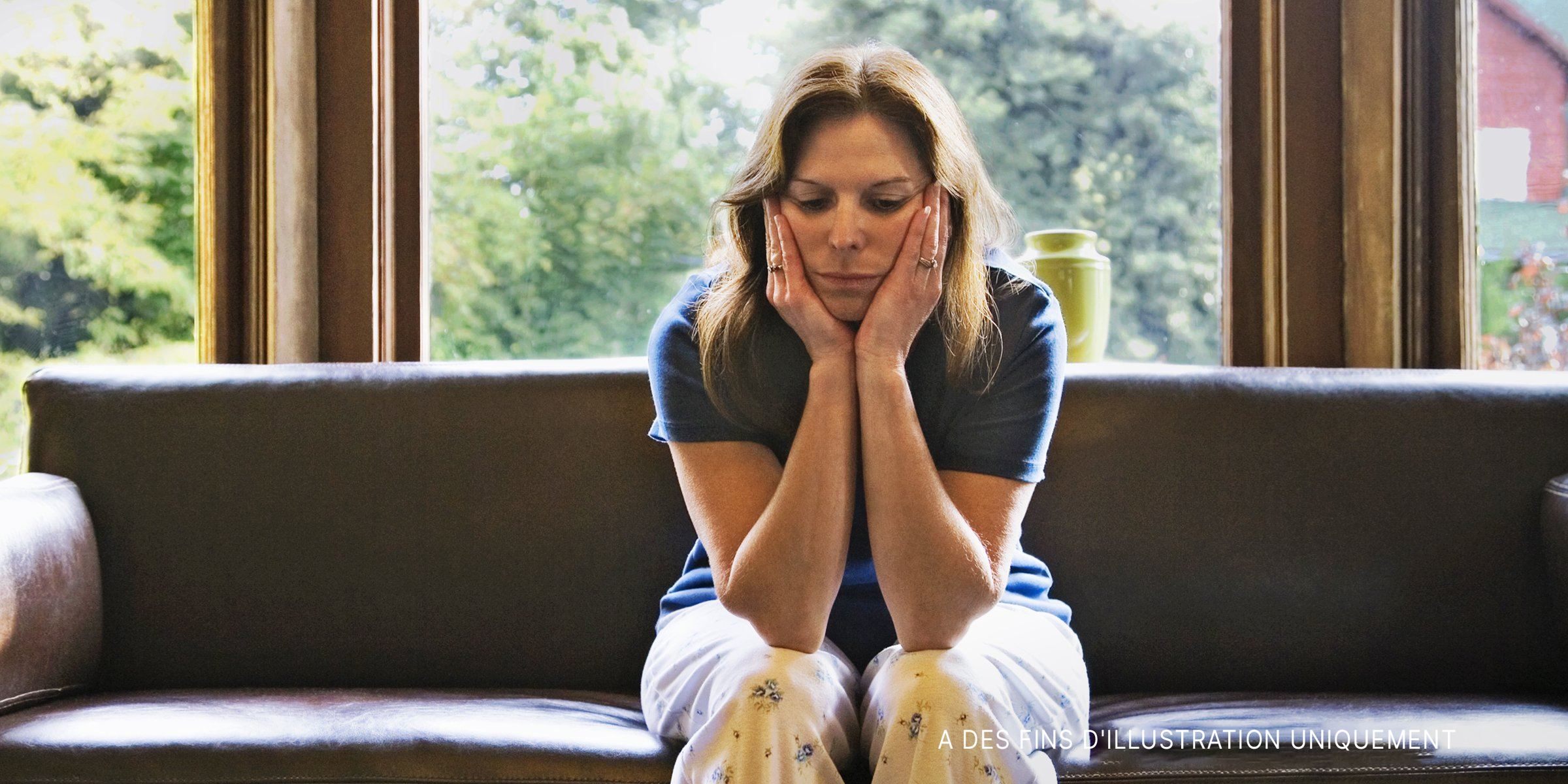 Une femme sur un canapé, inquiète. | Source : Getty Images