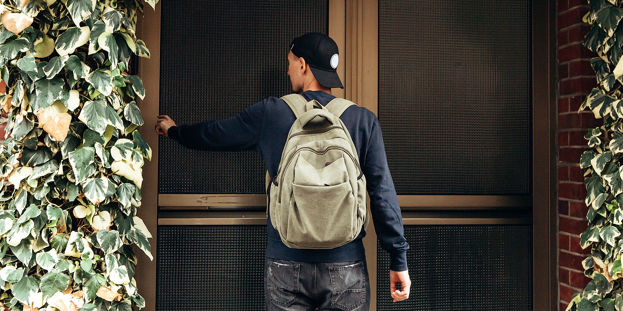 Un jeune homme avec un sac à dos qui frappe à une porte | Source : Shutterstock