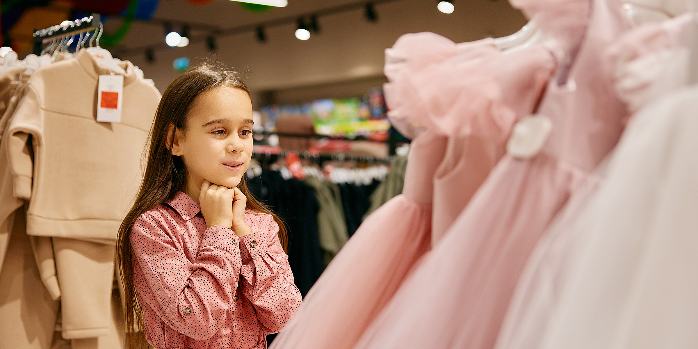 Une petite fille qui regarde une robe | Source : Shutterstock