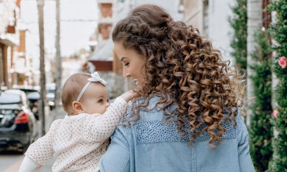 A woman holding her baby | Source: Midjourney