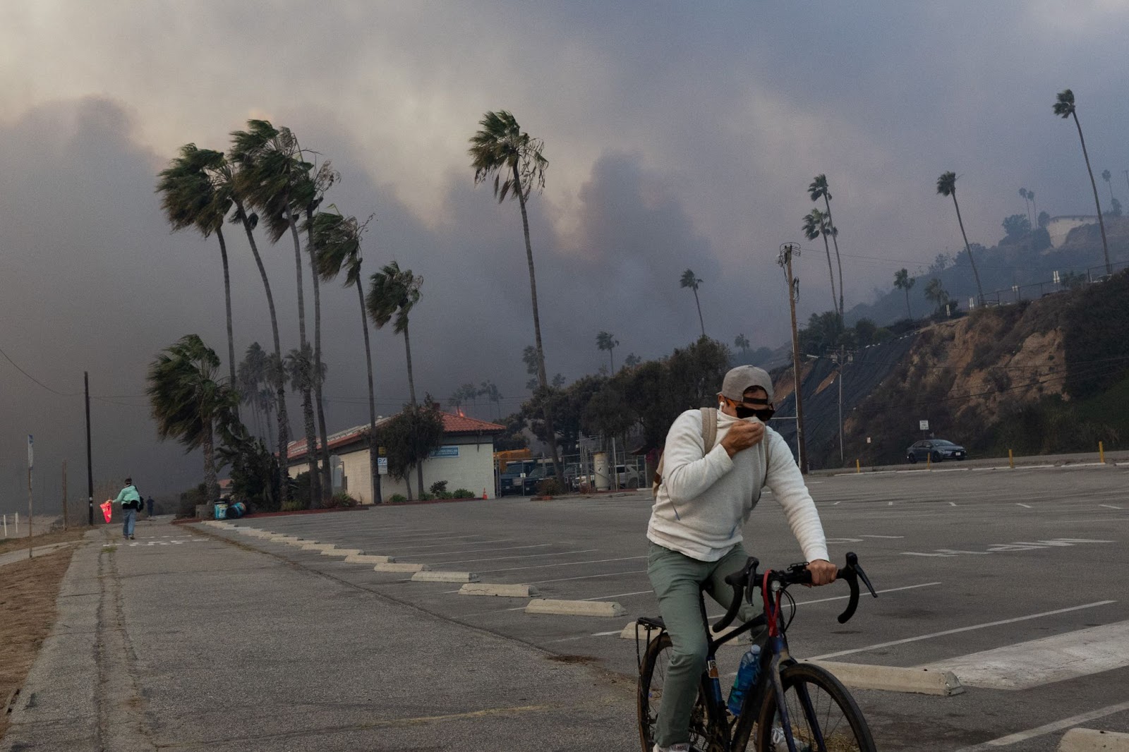 Un résident photographié en train de rouler à travers la fumée de l'incendie de Palisades, le 7 janvier 2025, à Pacific Palisades, Los Angeles, Californie. | Source : Getty Images