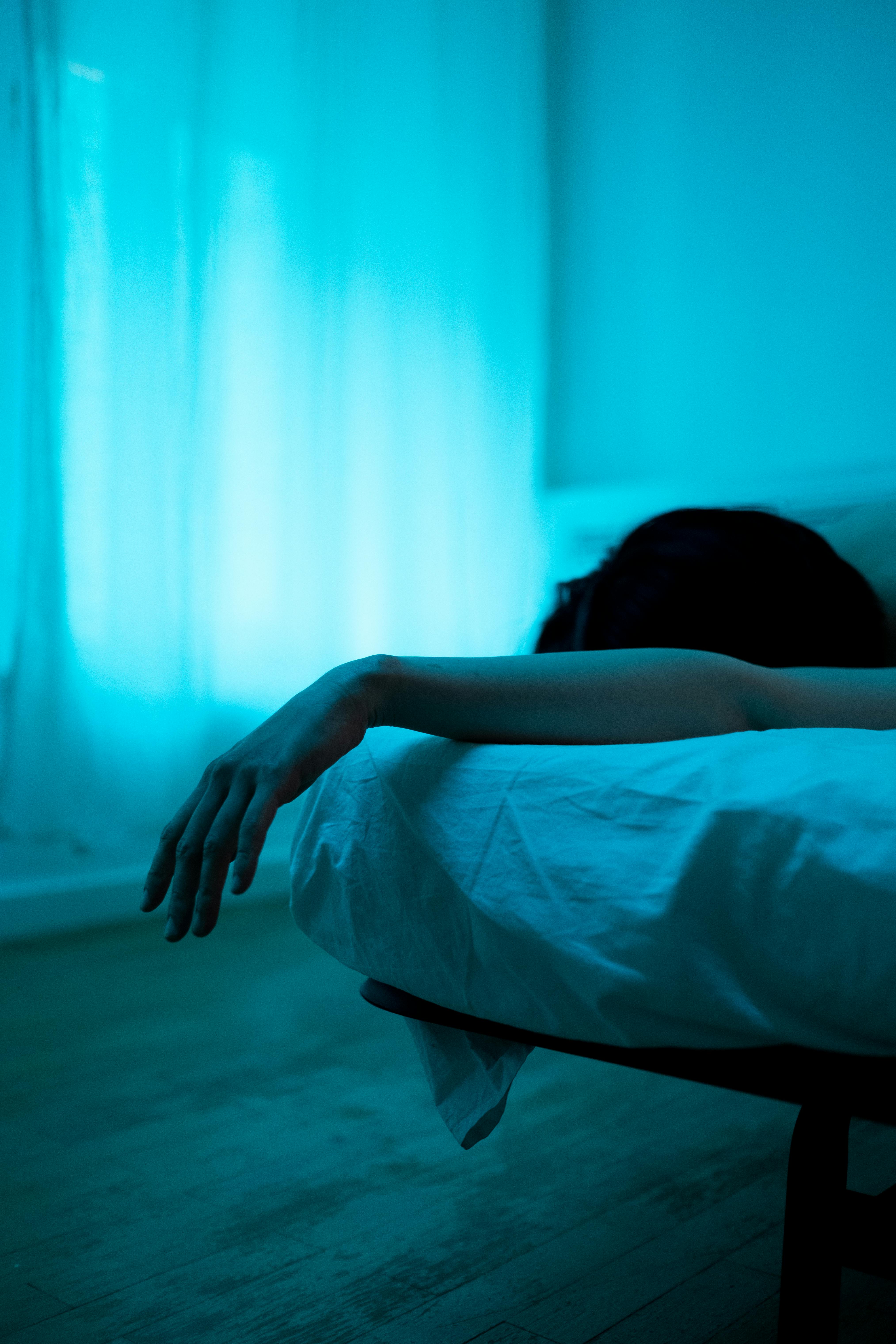 Une femme allongée dans son lit dans l'obscurité | Source : Pexels