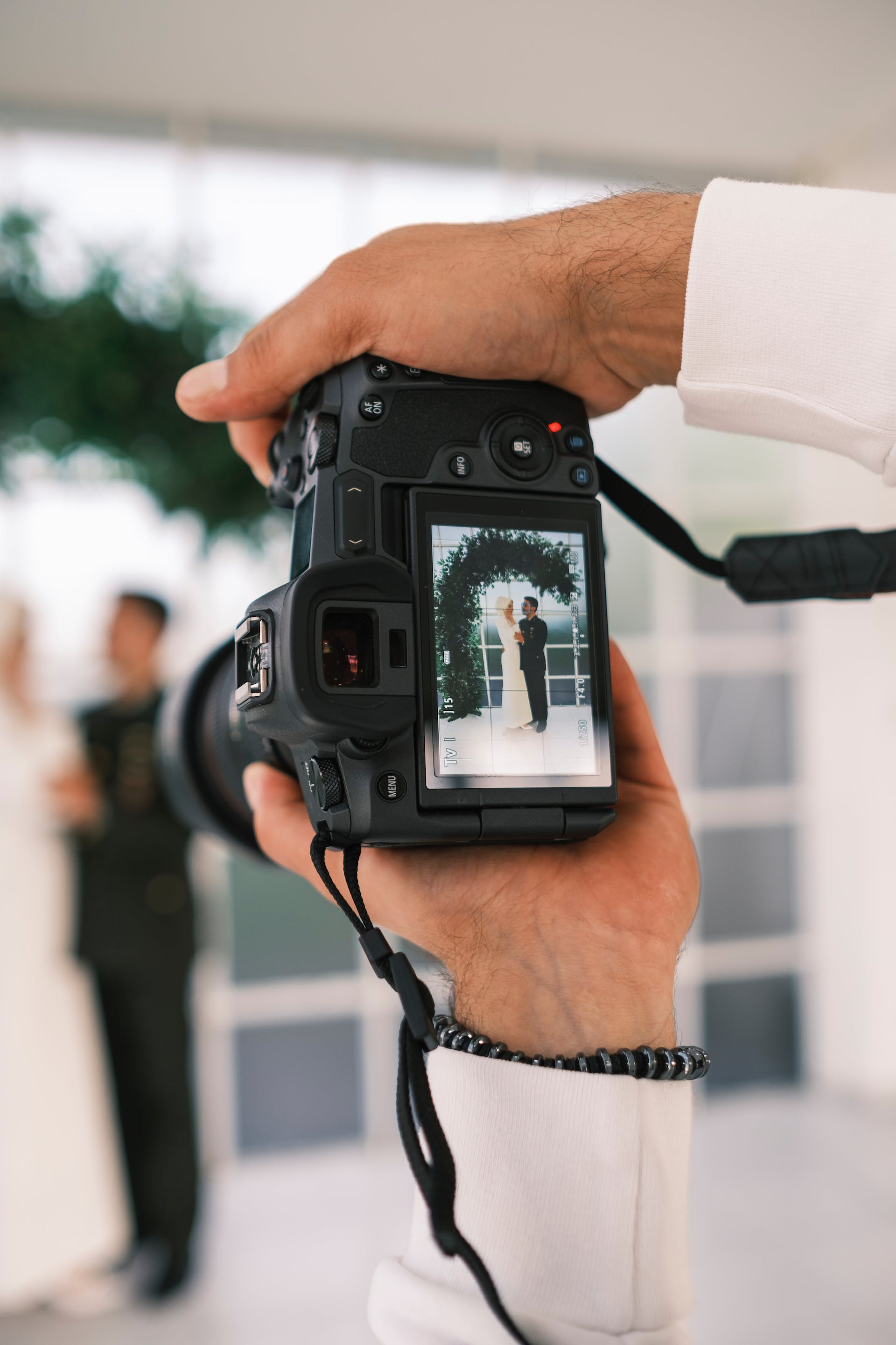 Un fotógrafo fotografiando a una pareja en su boda | Fuente: Pexels
