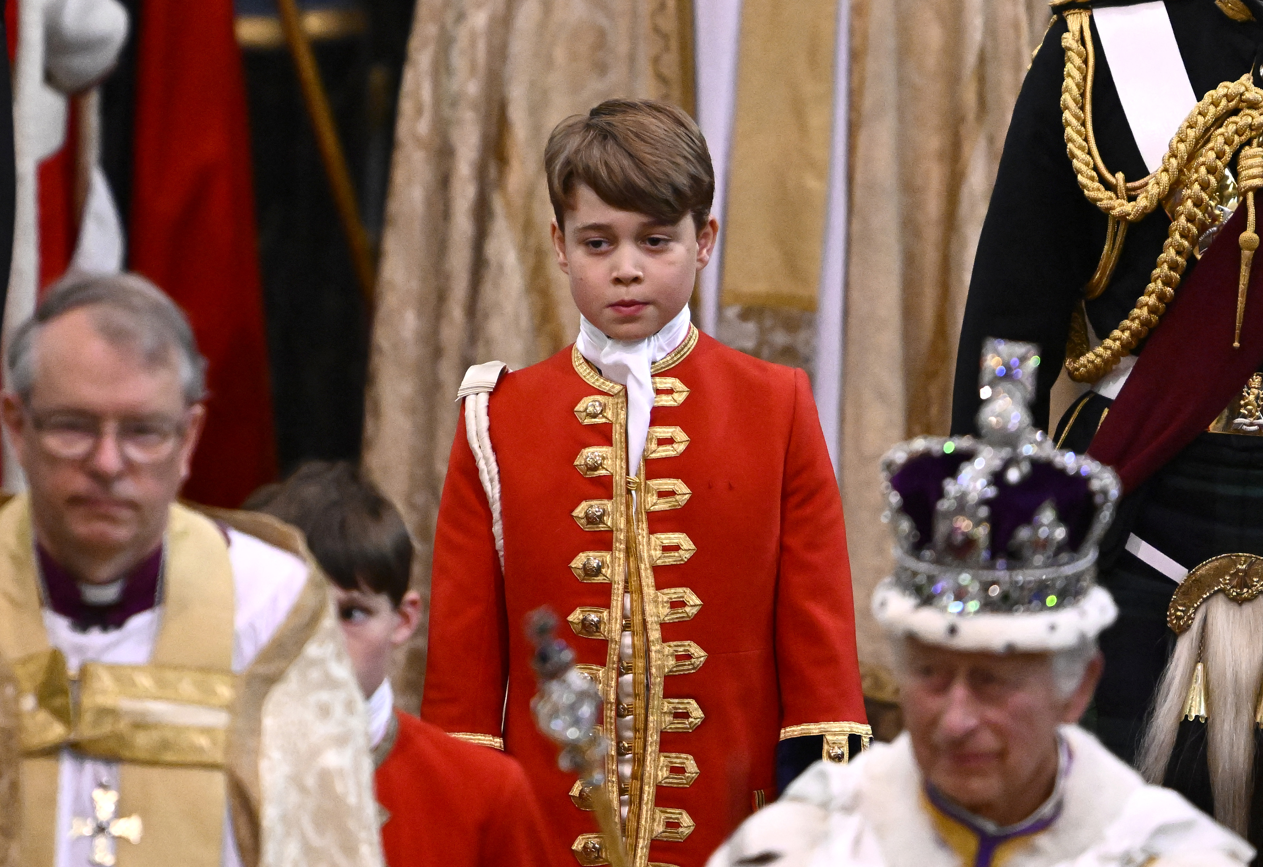 Le prince George de Galles et le roi de Grande-Bretagne Charles III portant la couronne d'État impériale quittent l'abbaye de Westminster après les cérémonies de couronnement dans le centre de Londres, le 6 mai 2023. | Source : Getty Images