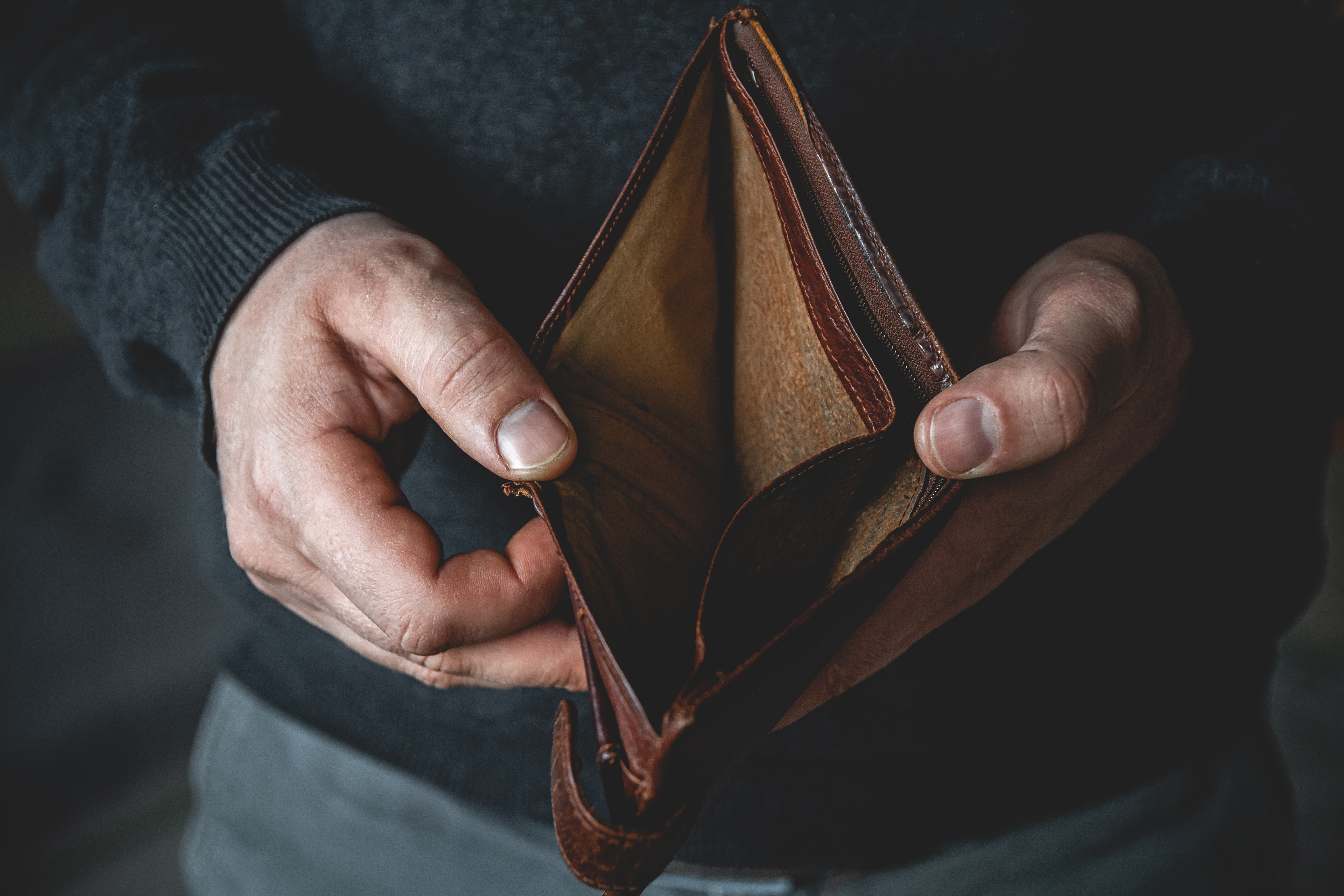 Un homme tenant un portefeuille vide | Source : Shutterstock