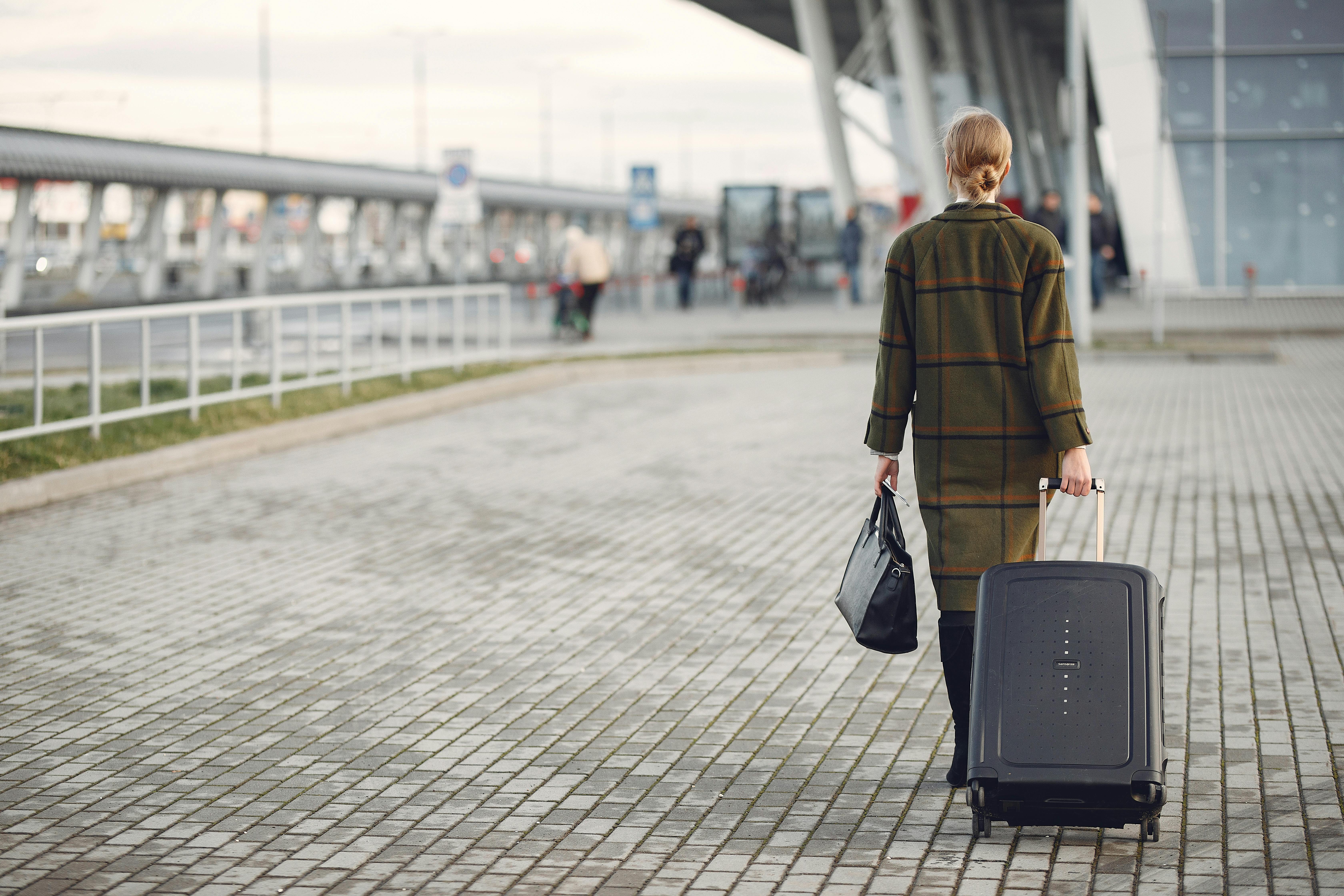 Une femme s'éloignant avec ses bagages | Source : Pexels