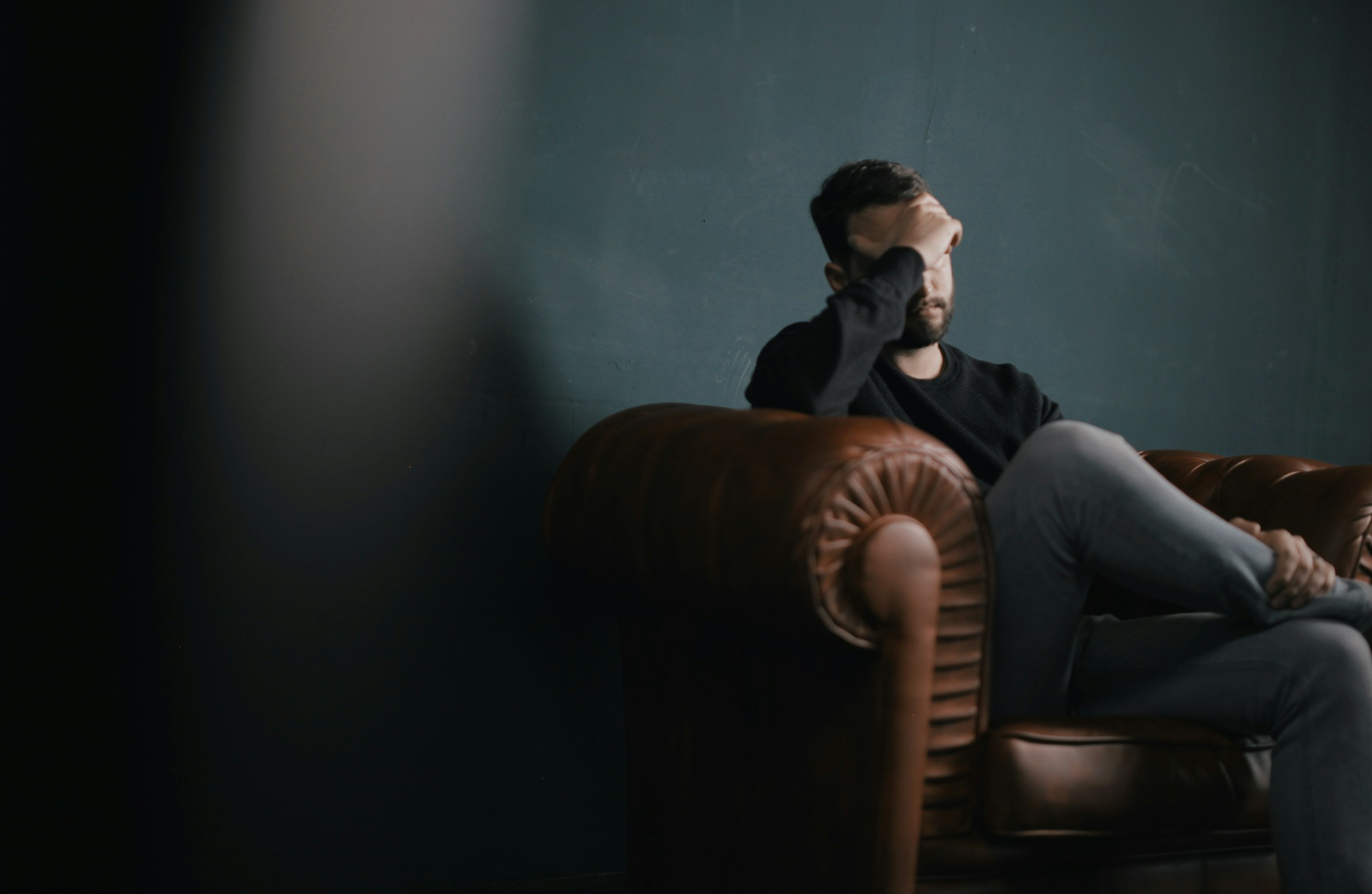 Un homme en détresse assis sur un canapé | Source : Pexels