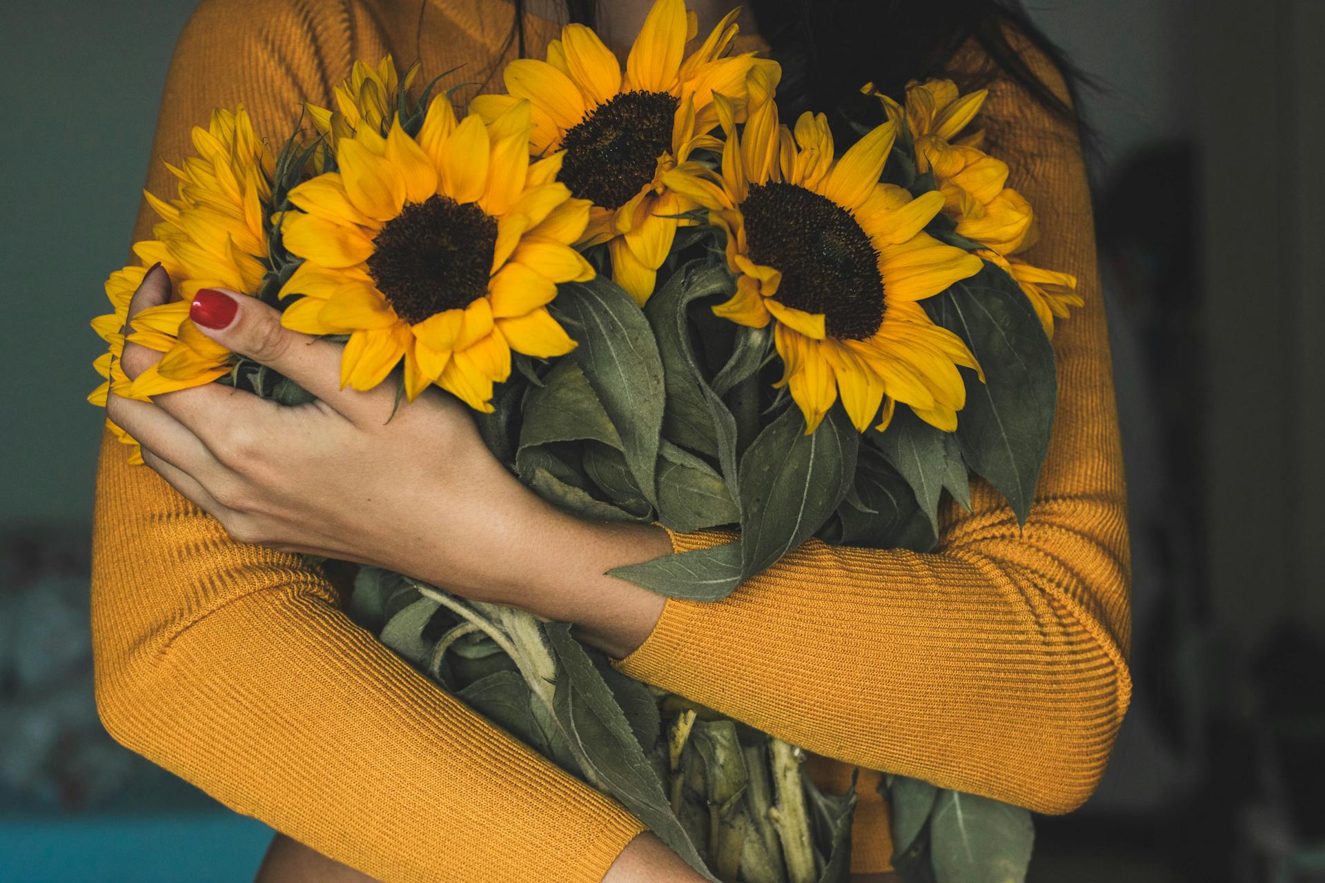 Une femme tenant un bouquet de tournesols | Source : Pexels