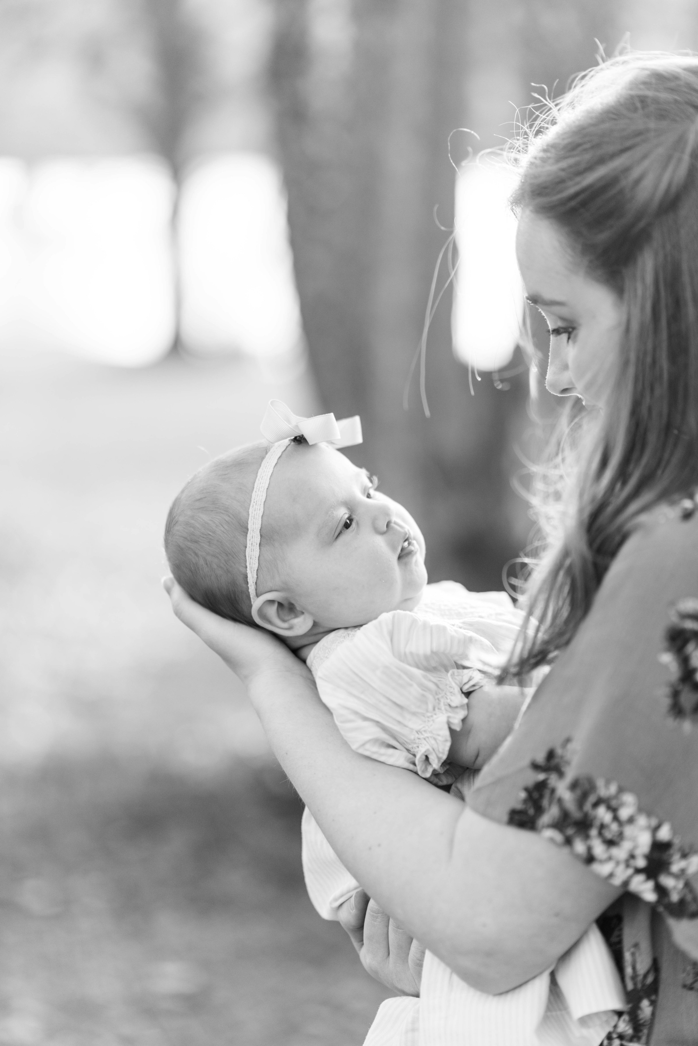 Photo en niveaux de gris d'une femme tenant une petite fille dans ses bras | Source : Unsplash