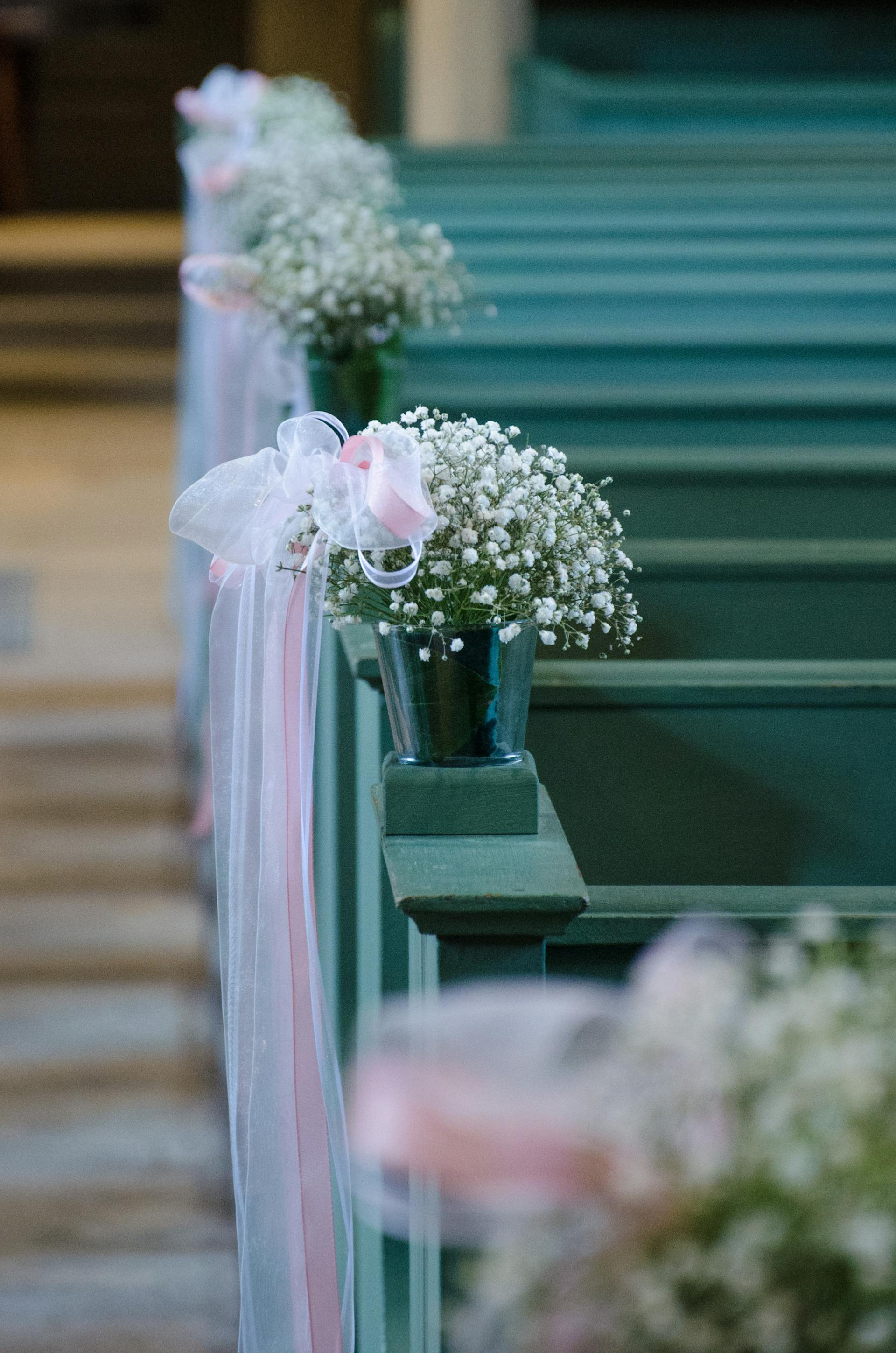 Fleurs et tulle le long des bancs d'église | Source : Pexels