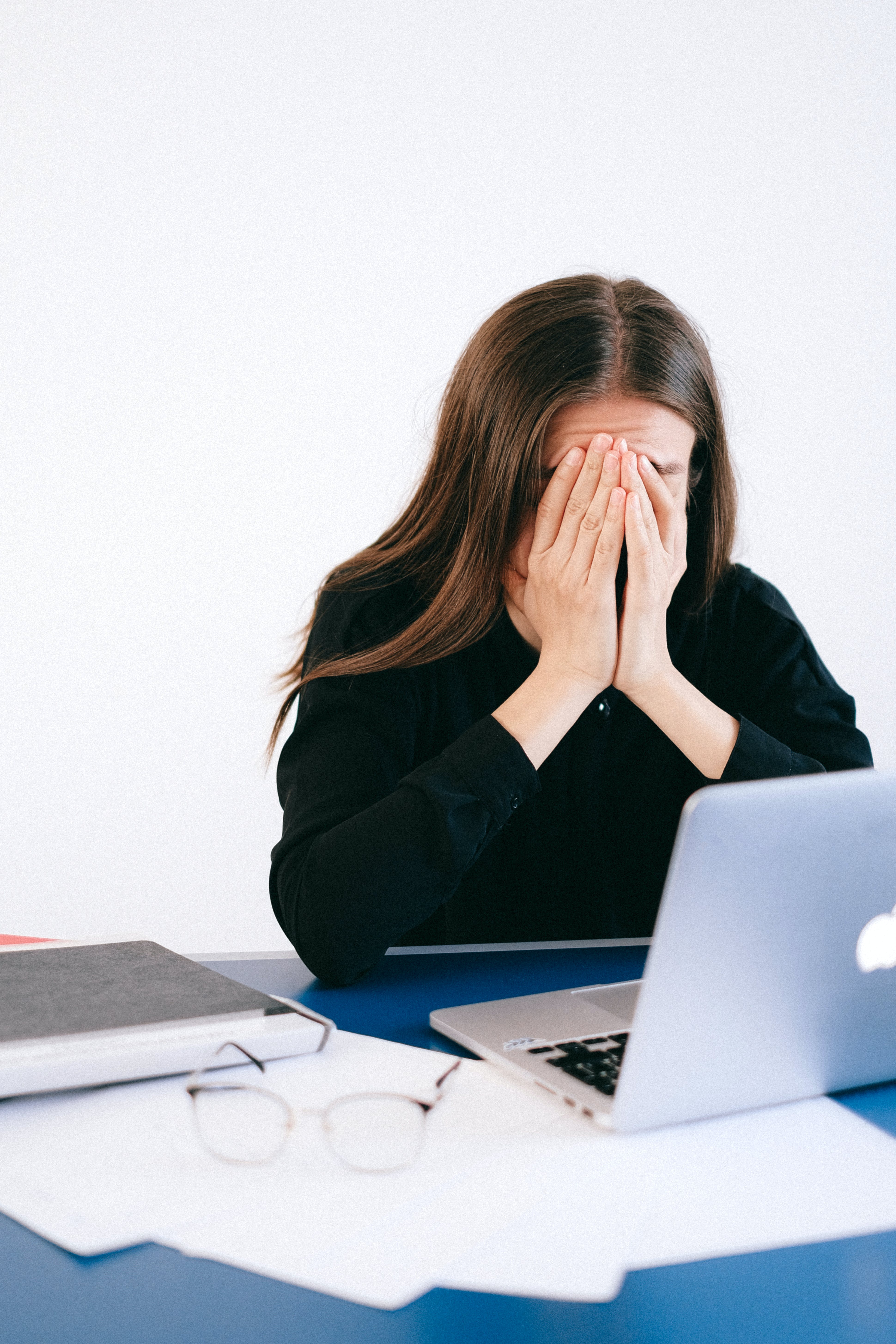 A stressed woman covering her face. | Source: Pexels