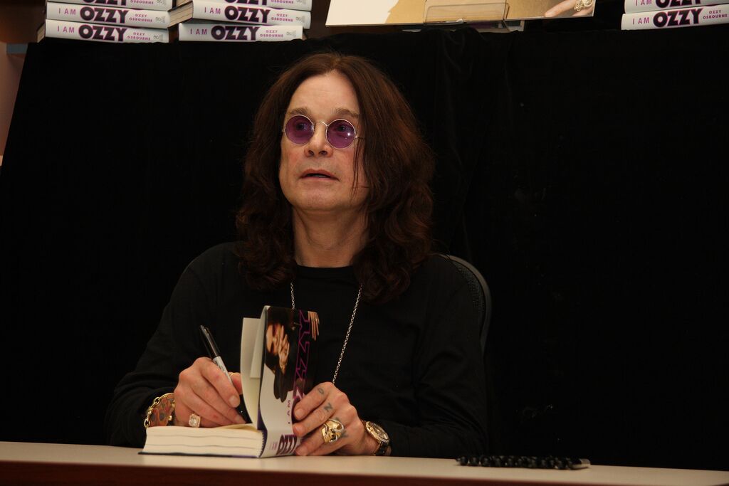 Ozzy Osbourne signe des exemplaires du livre "I Am Ozzy". | Photo : Flickr