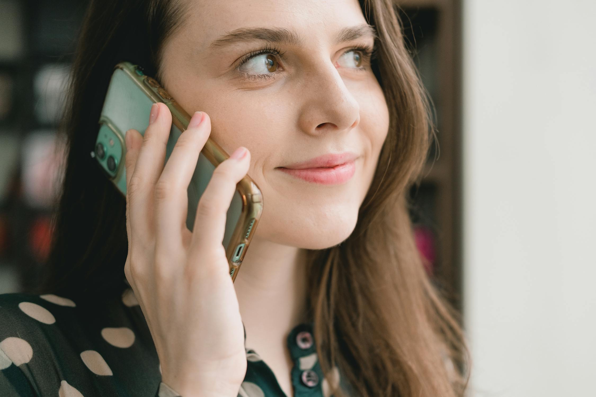 Une femme souriante qui parle au téléphone | Source : Pexels