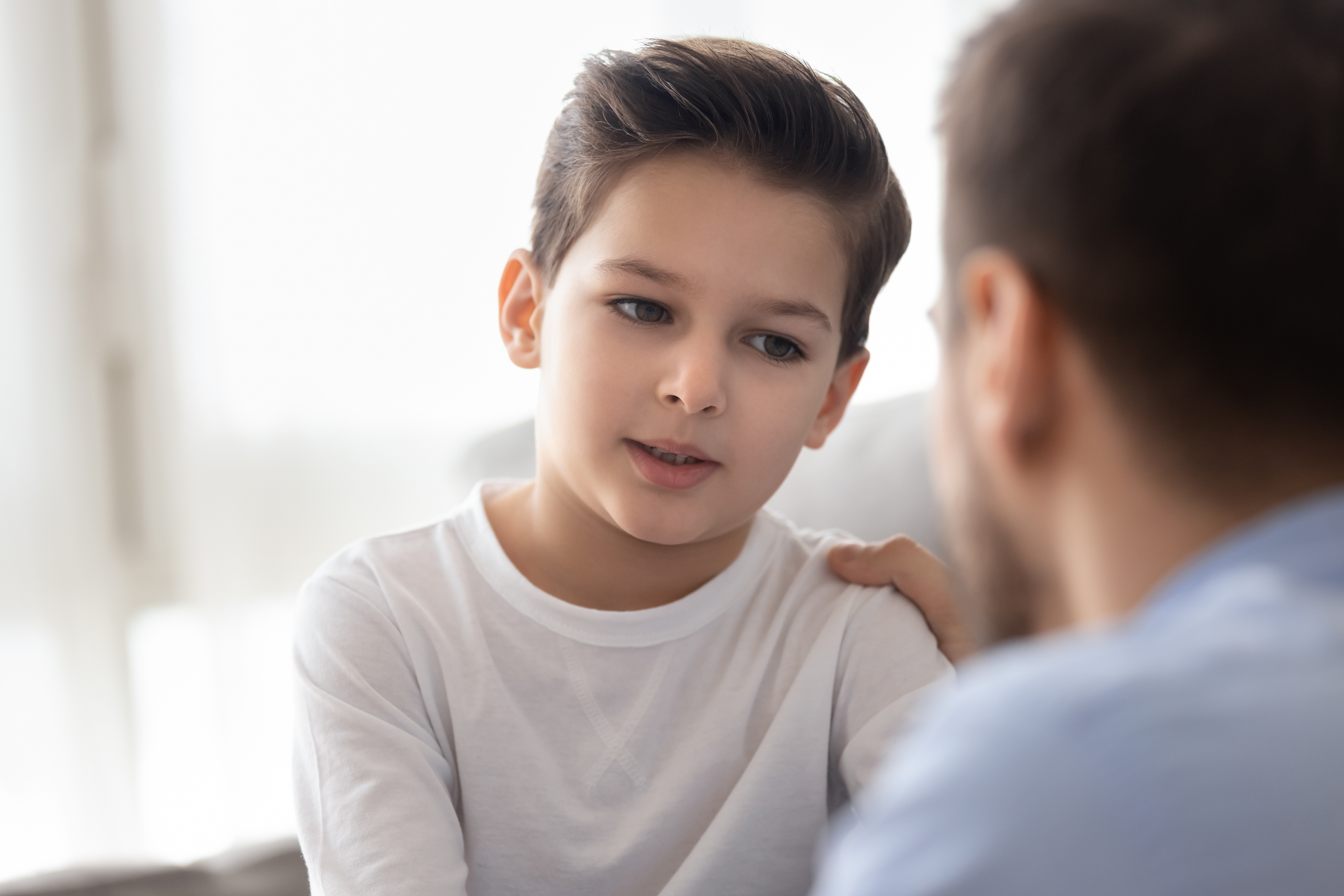 Um homem conversando com um menino | Fonte: Shutterstock