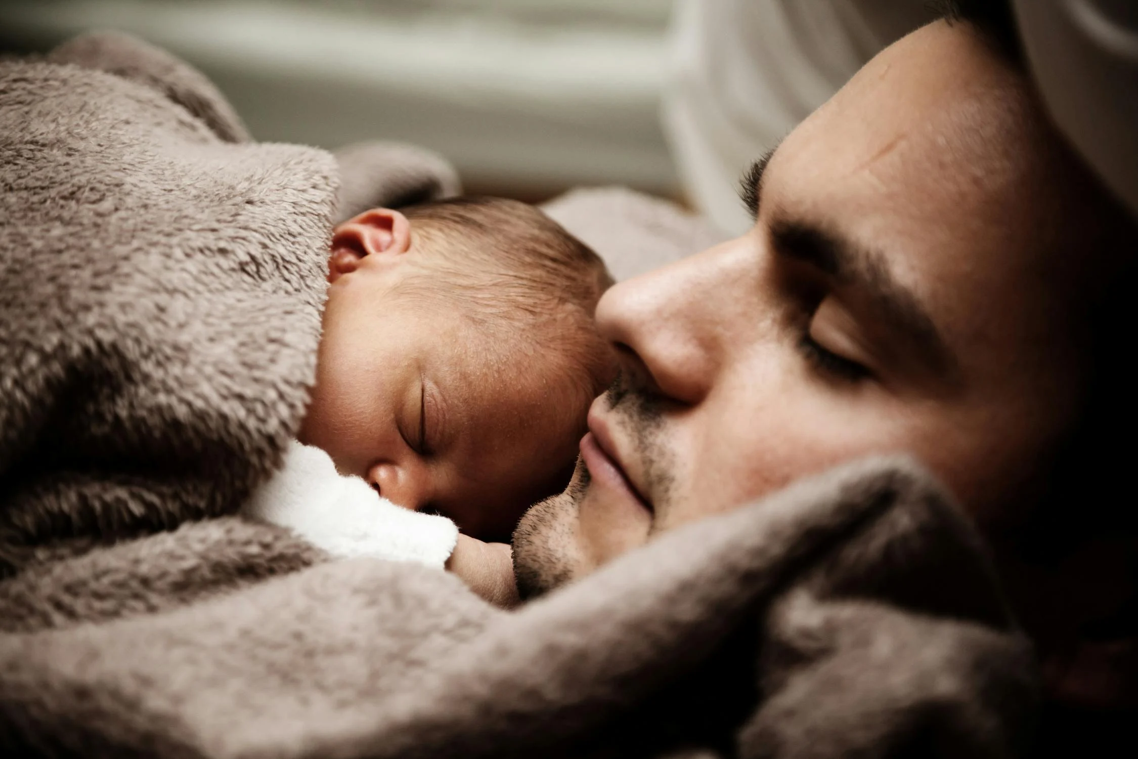 Un père dormant avec son fils nouveau-né ⏐ Source : Pexels