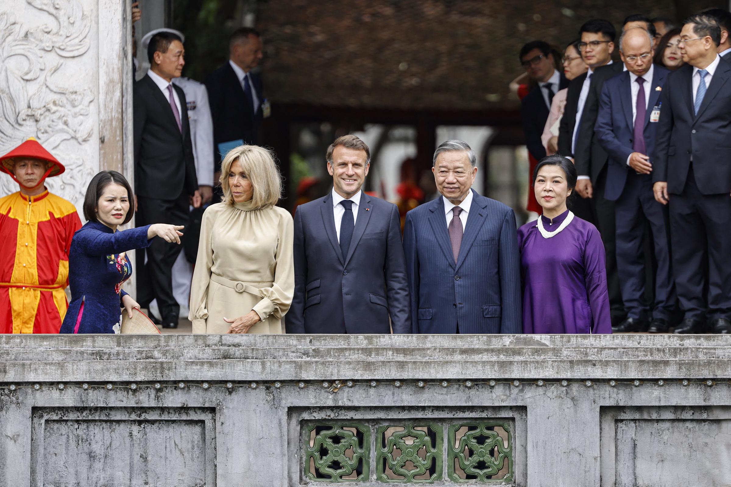 Le président français Emmanuel Macron, son épouse Brigitte Macron (au centre à gauche), le secrétaire général du Parti communiste vietnamien To Lam et son épouse Ngo Phuong Ly (au centre à droite) visitent le Temple de la Littérature à Hanoï le 26 mai 2025 I Source : Getty Images