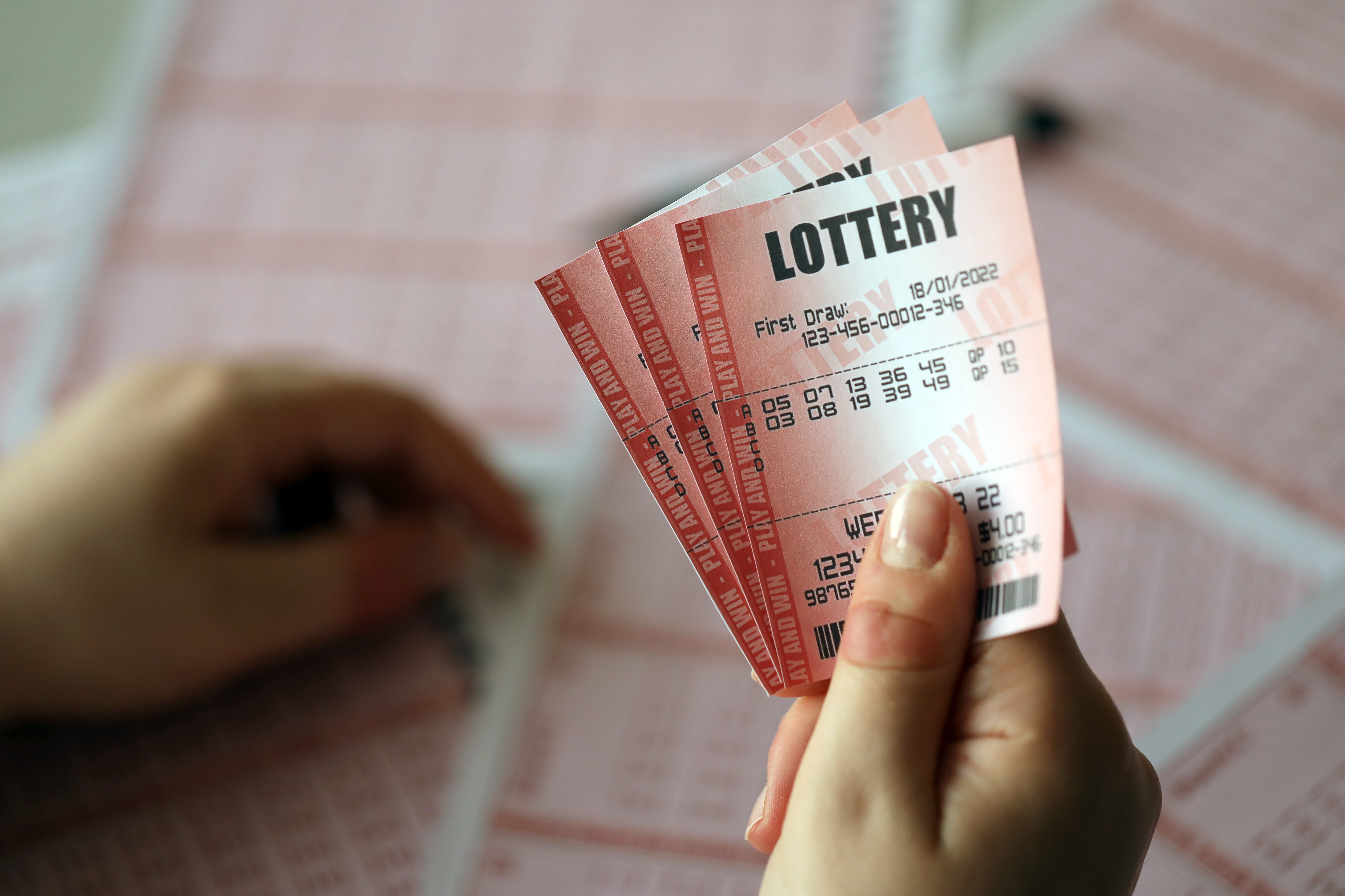 Une personne tenant des billets de loterie | Source : Shutterstock