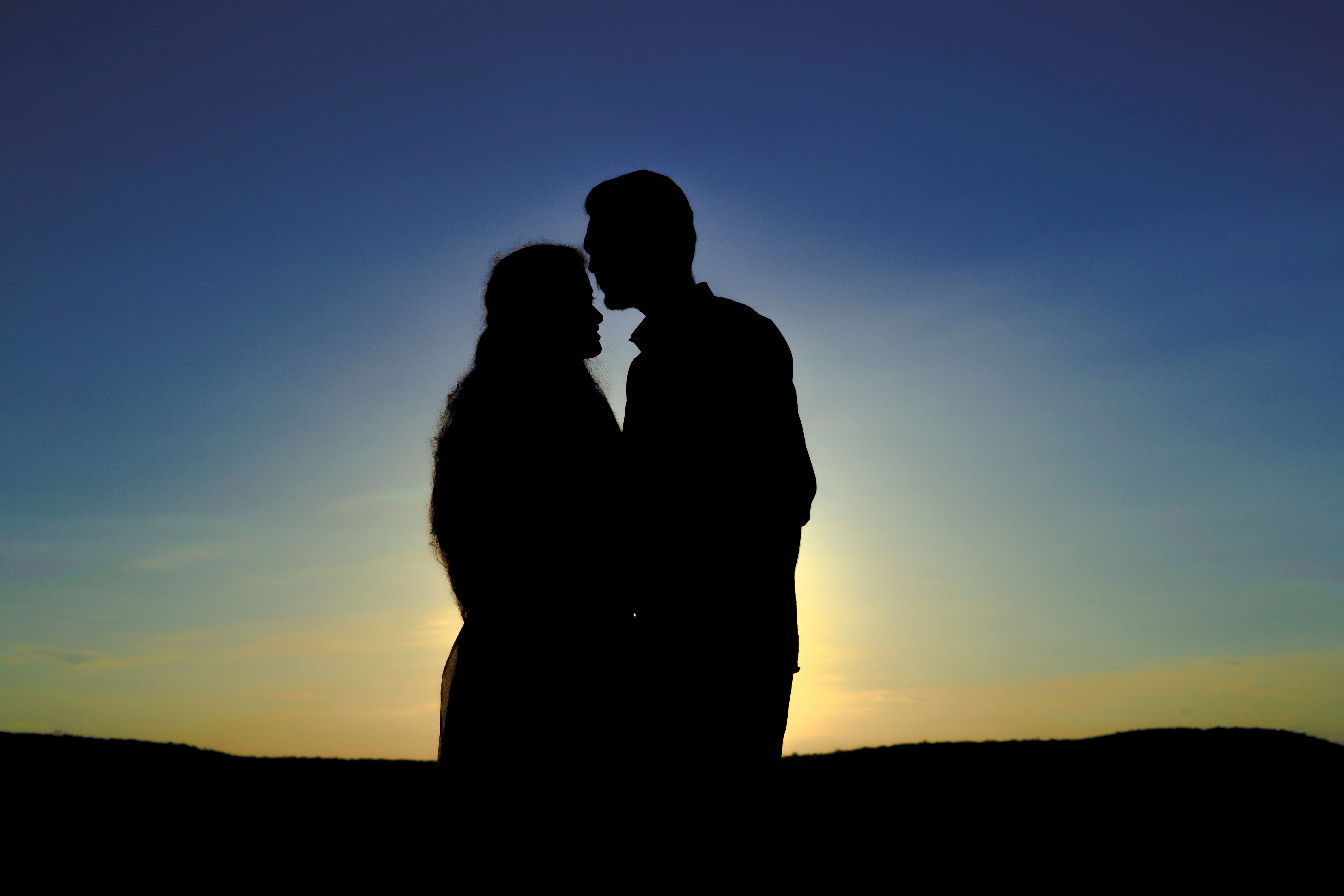 Silhouette d'un couple qui s'embrasse au lever du soleil | Source : Pexels