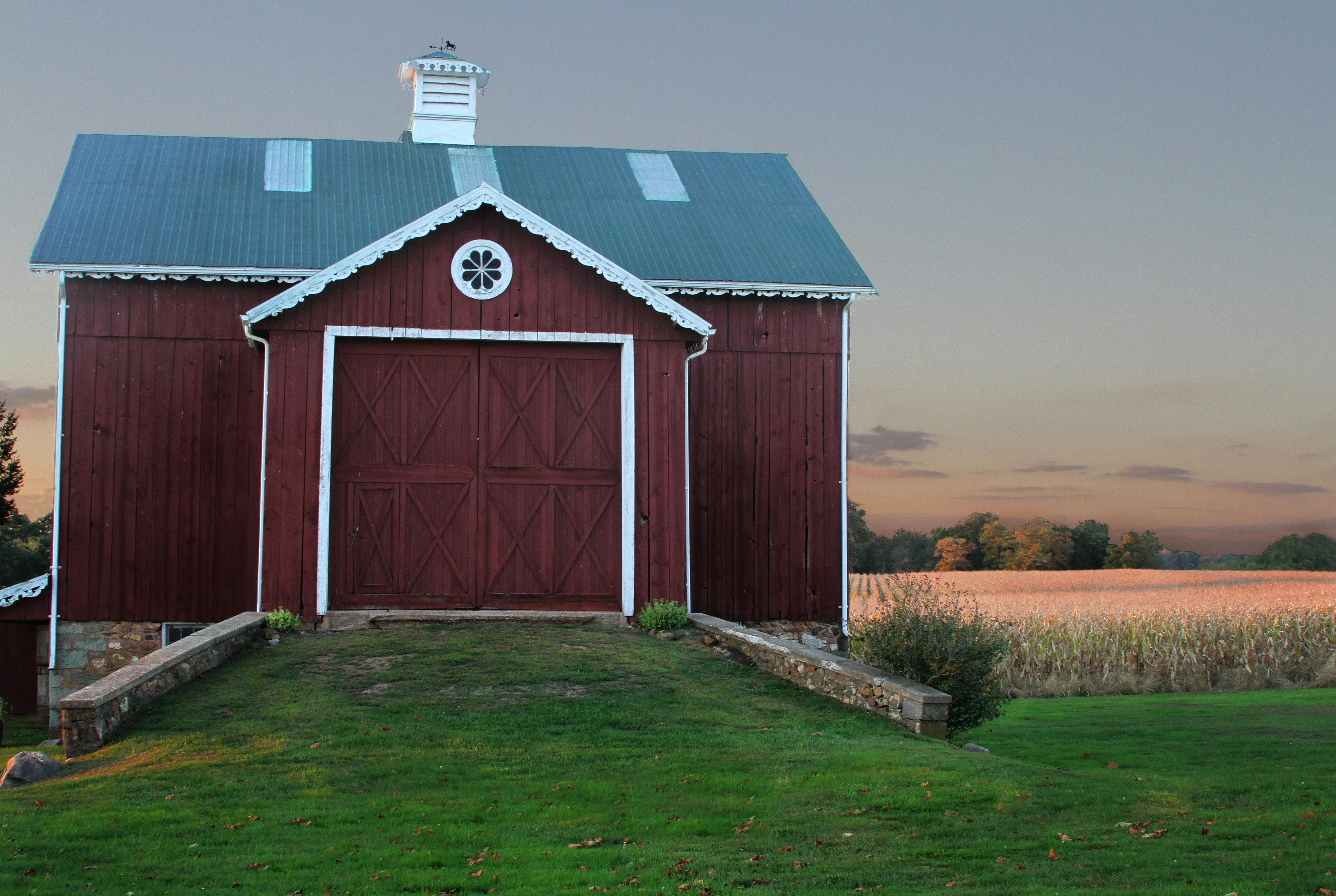 Une grange rouge foncé avec des portes fermées | Source : Pexels