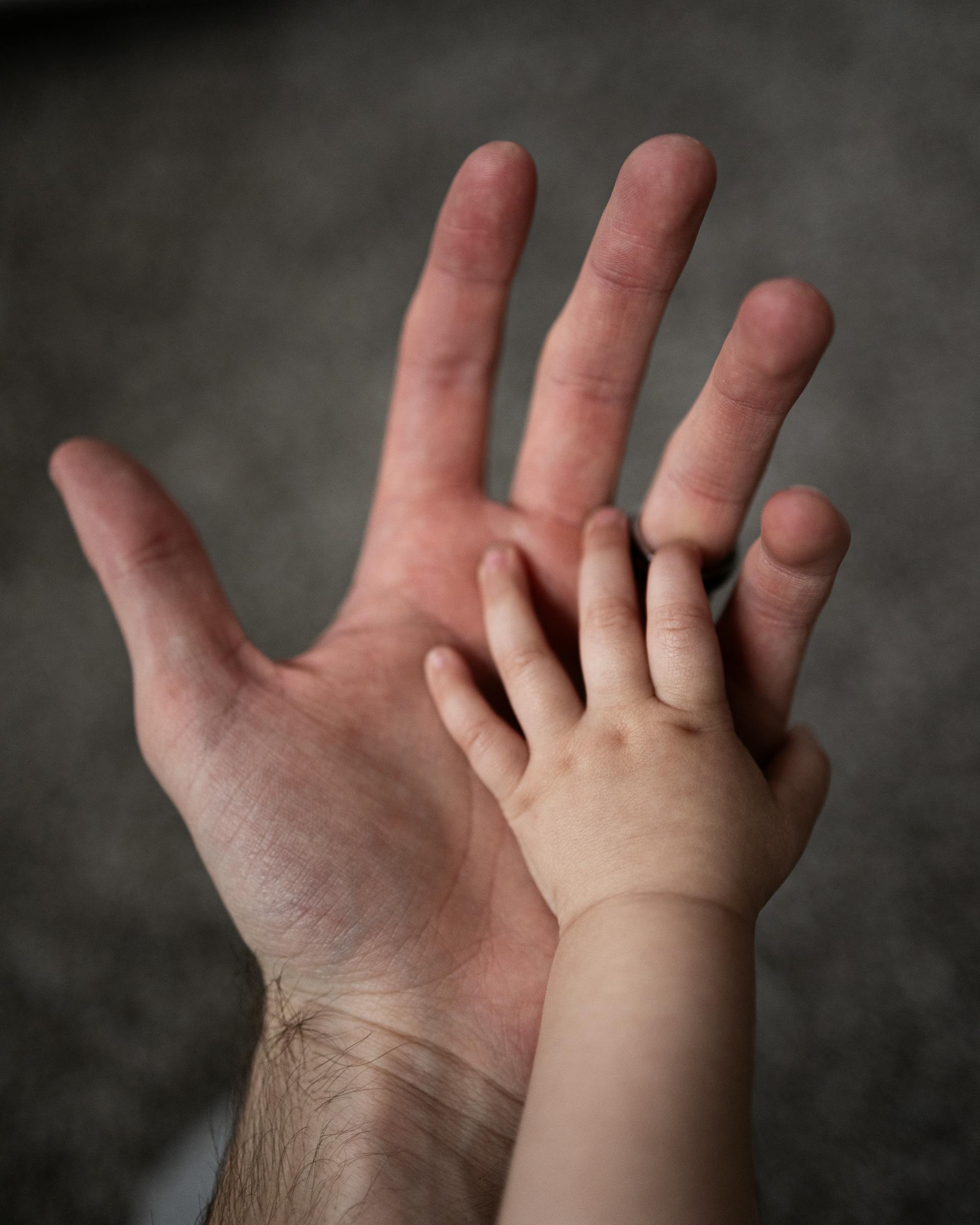 Les mains d'un homme et d'un bébé | Source : Pexels
